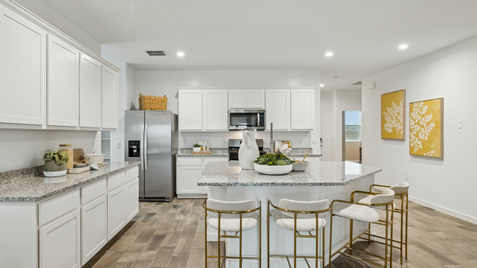 Bright and spacious kitchen with granite countertops, stainless steel appliances, and an island with bar seating.