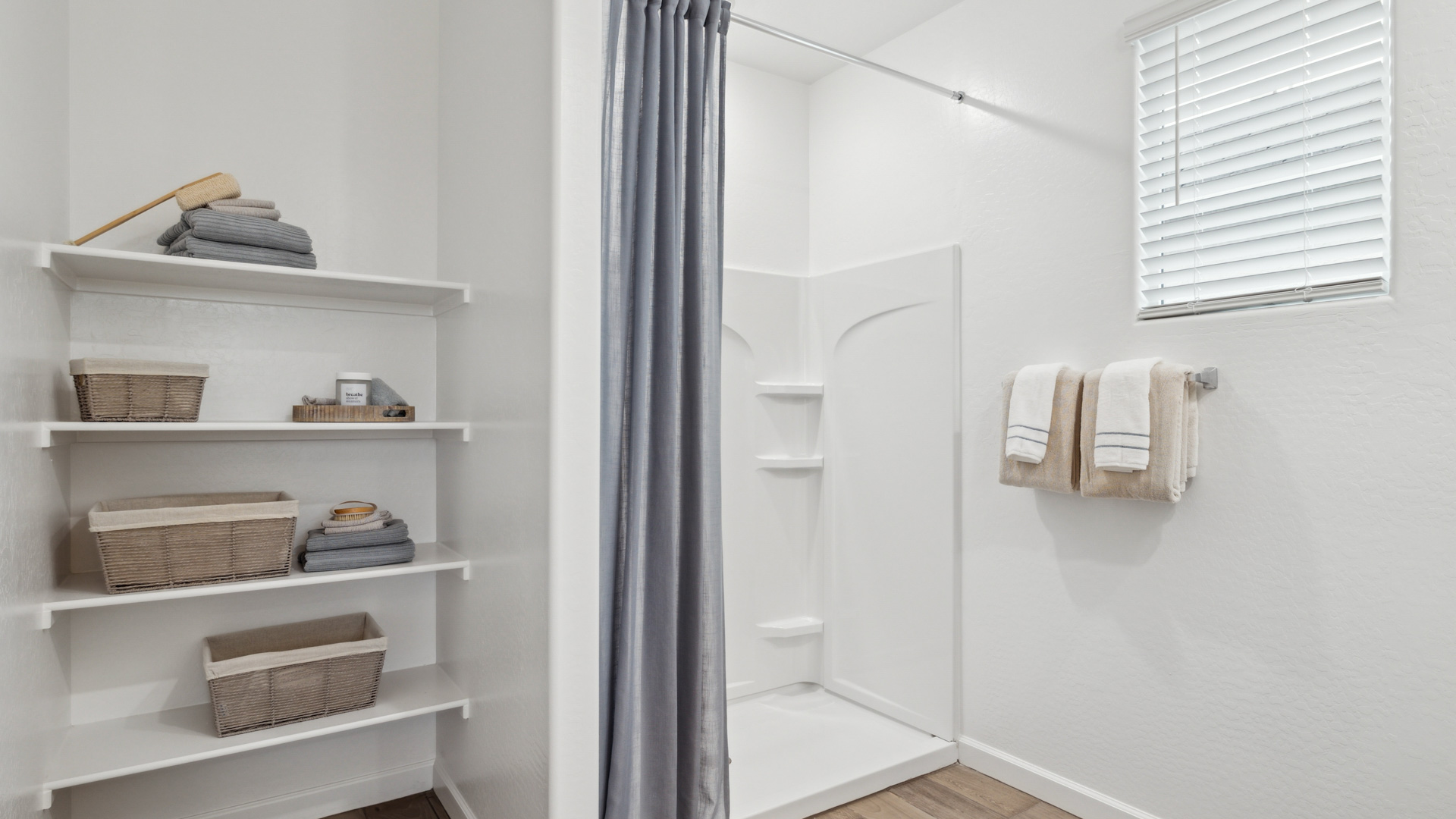 Modern primary bathroom with double vanity, granite countertops with a walk-in shower and a walk-in closet.