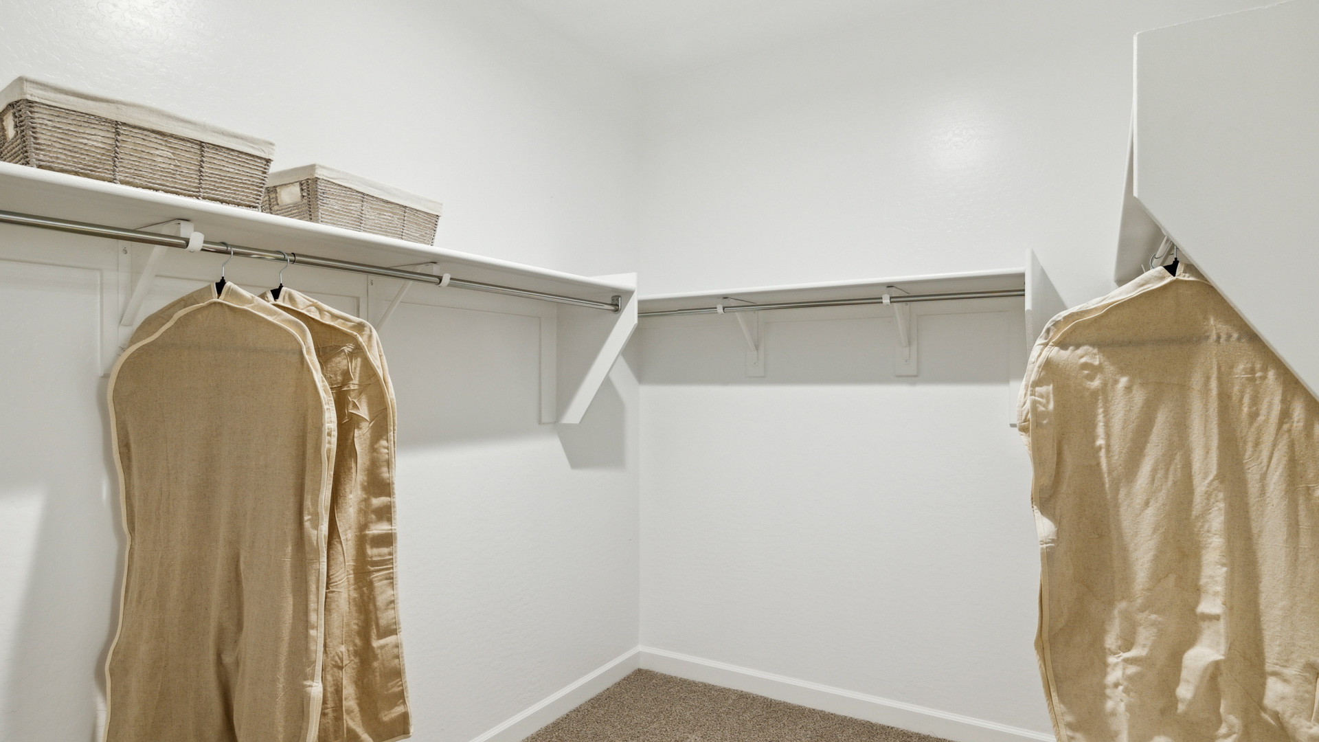 Modern primary bathroom with double vanity, granite countertops with a walk-in shower and a walk-in closet.