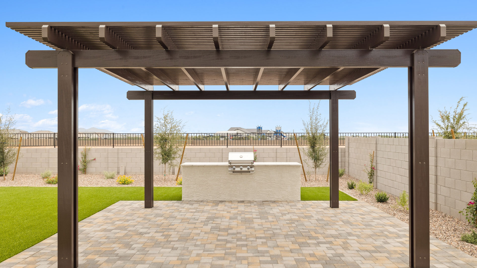 Outdoor covered patio with seating area overlooking a well-maintained lawn, perfect for relaxation.