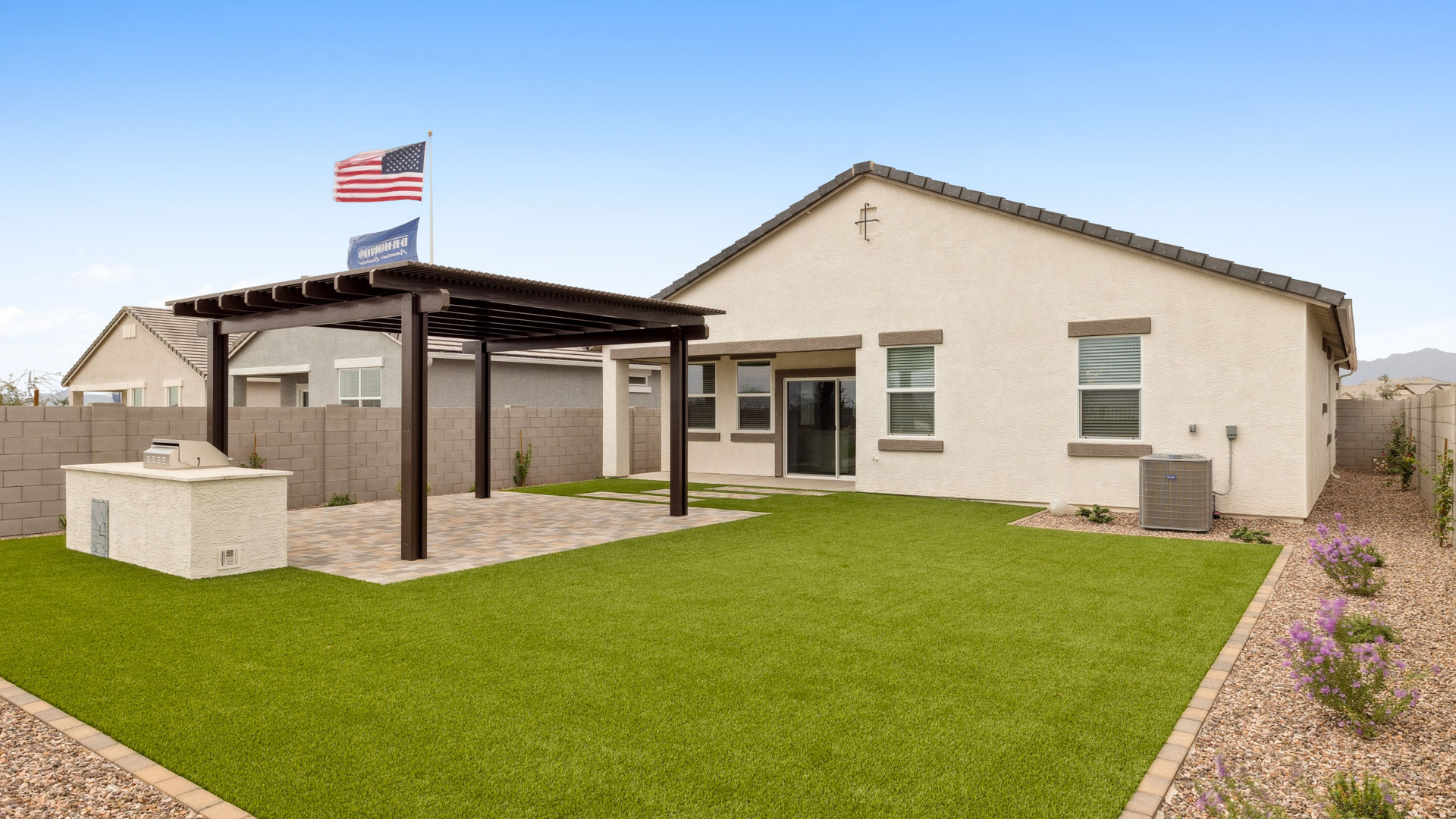 Outdoor covered patio with seating area overlooking a well-maintained lawn, perfect for relaxation.