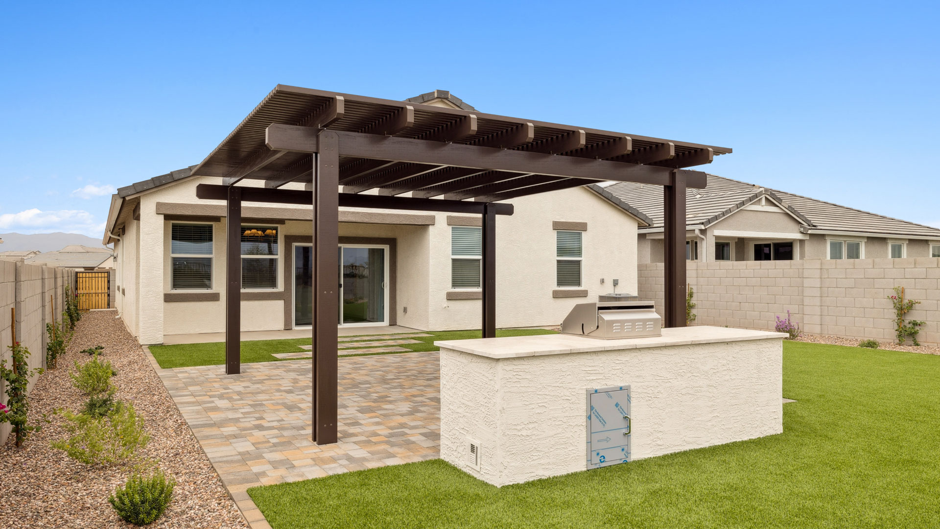 Outdoor covered patio with seating area overlooking a well-maintained lawn, perfect for relaxation.