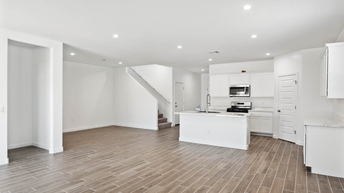 A well-organized living room that includes a kitchen and dining area, creating a warm and welcoming environment for gatherings.