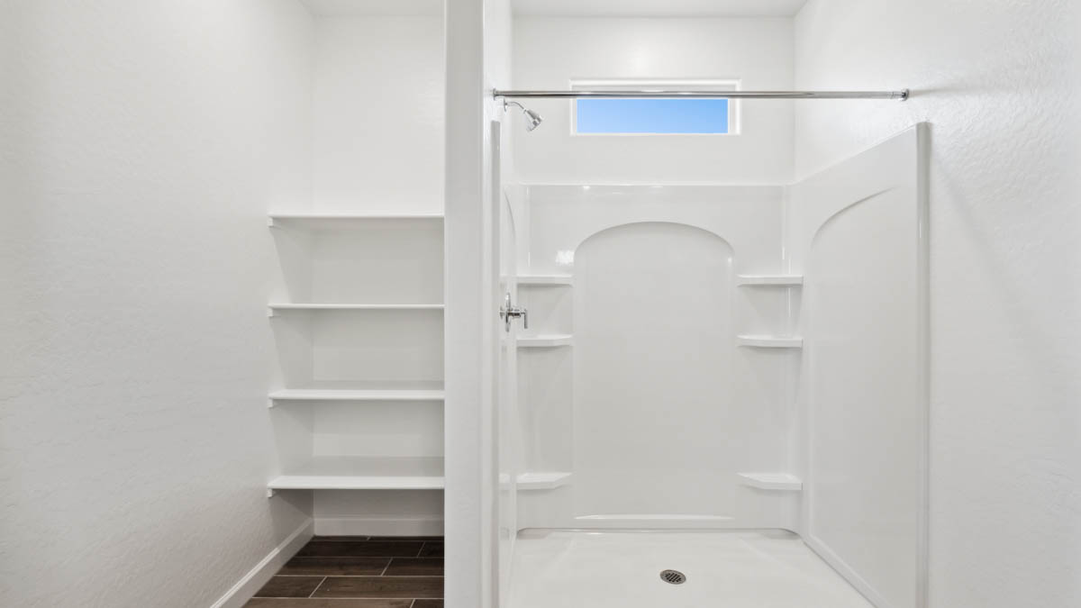 Modern primary bathroom with double vanities, with a walk-in shower and a walk-in closet.