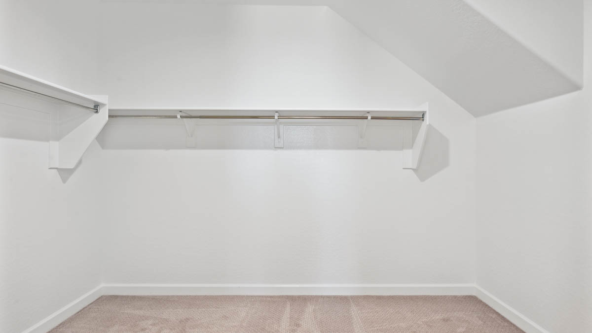 Modern primary bathroom with double vanities, with a walk-in shower and a walk-in closet.