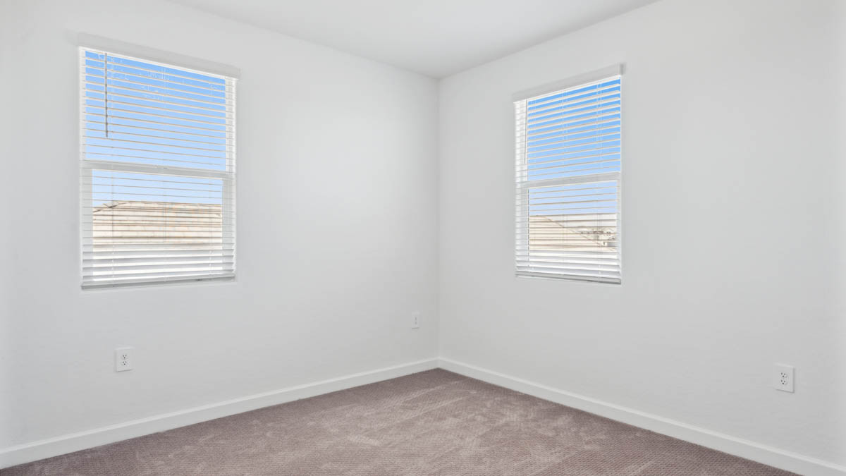 Upstairs bedroom featuring neutral-toned walls, carpeted flooring, and a large closet.