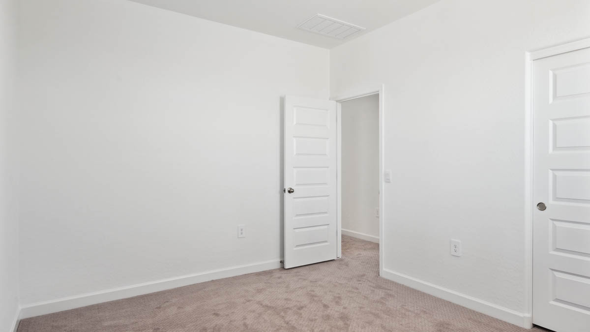 Upstairs bedroom featuring neutral-toned walls, carpeted flooring, and a large closet.