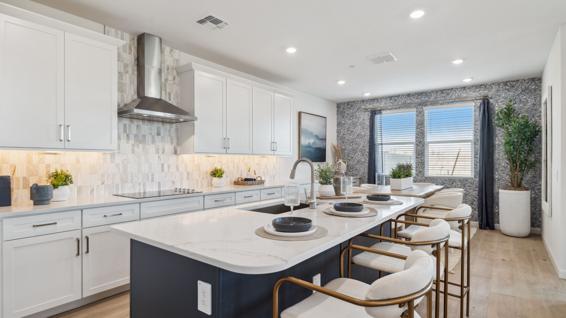 Bright and spacious kitchen with quartz countertops, stainless steel appliances, and an island with bar seating.