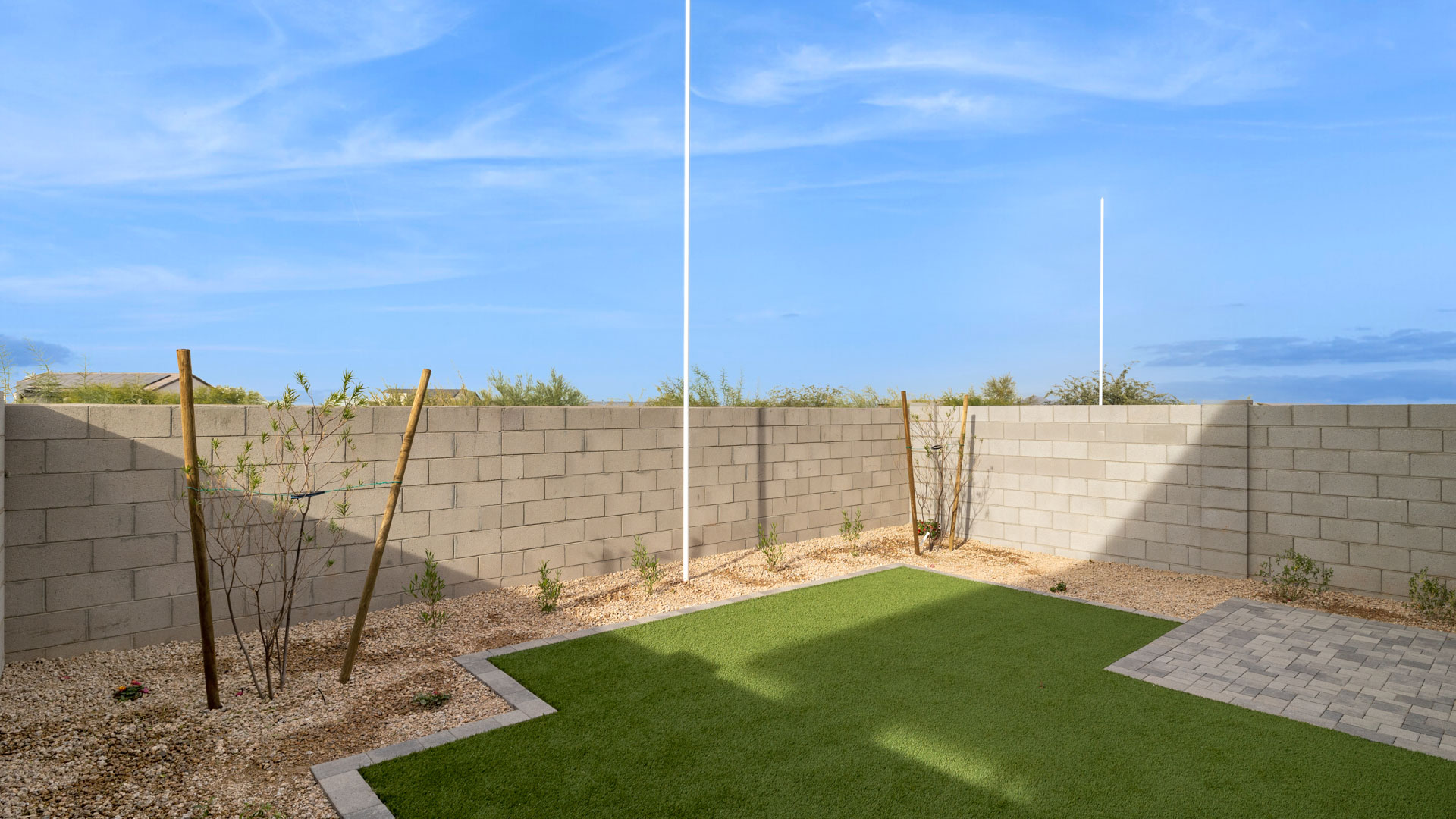 Outdoor covered patio with seating area overlooking a well-maintained lawn, perfect for relaxation.