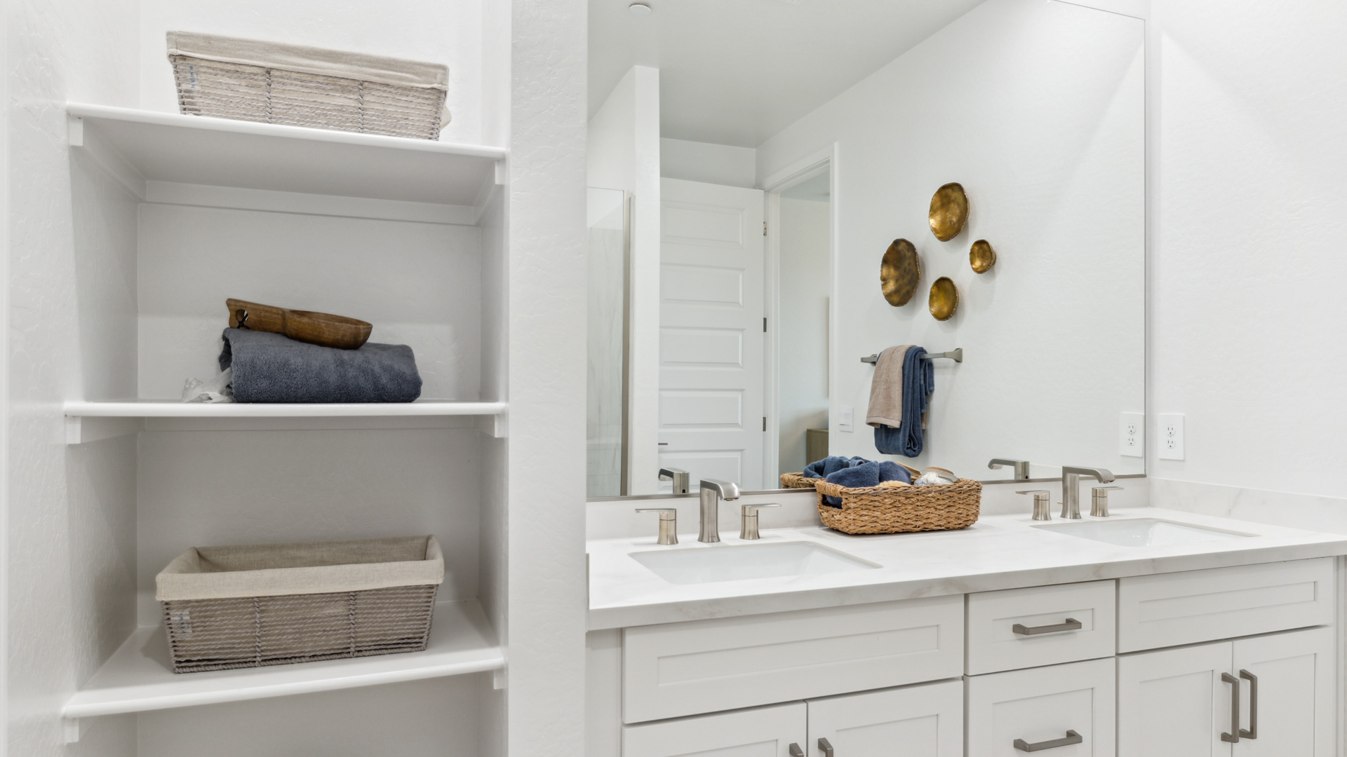 Modern primary bathroom with double vanities, quartz countertops with a walk-in shower and a walk-in closet.