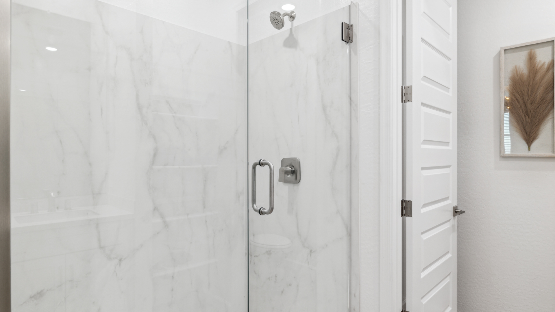 Modern primary bathroom with double vanities, quartz countertops with a walk-in shower and a walk-in closet.
