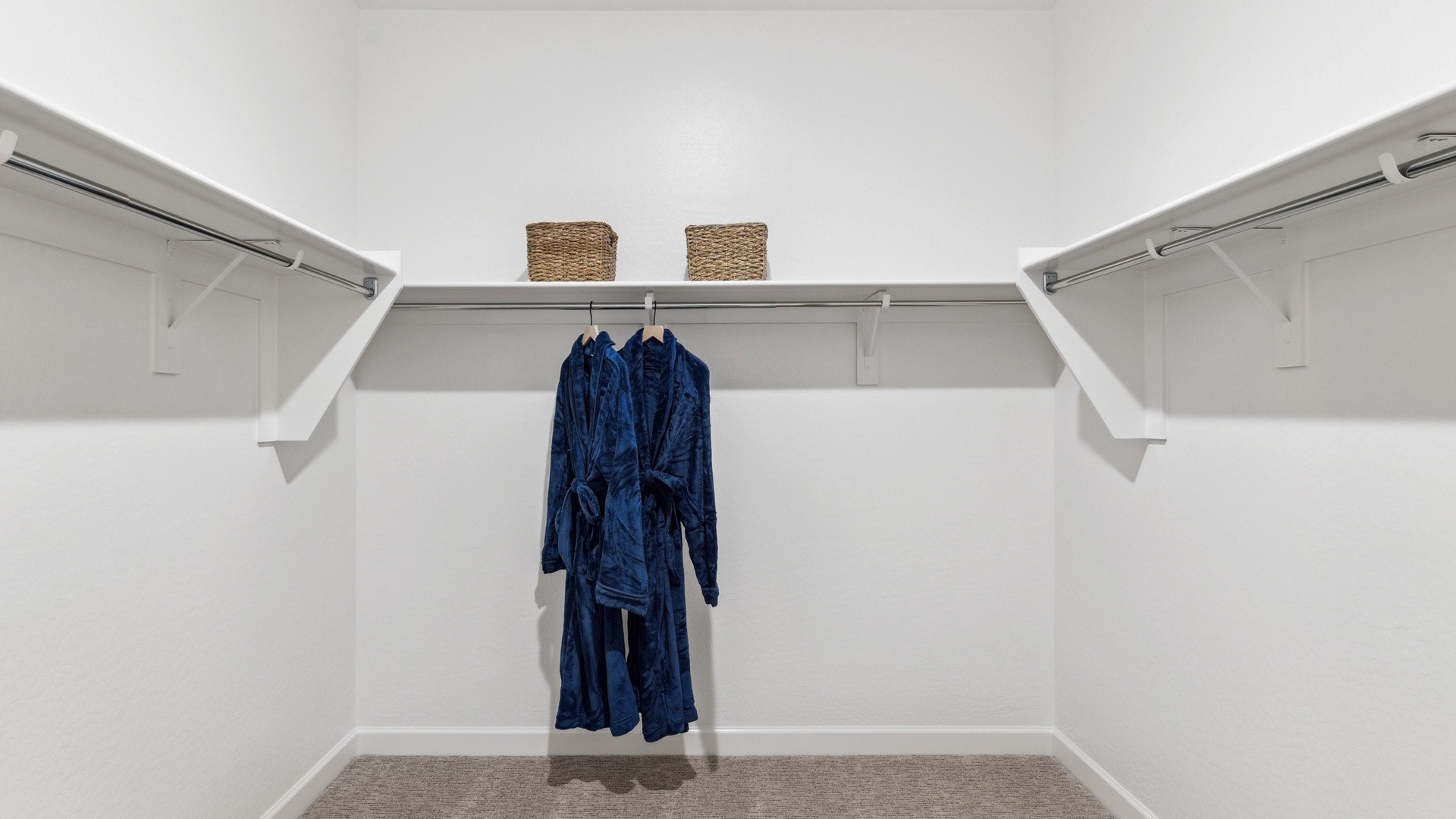 Modern primary bathroom with double vanities, quartz countertops with a walk-in shower and a walk-in closet.