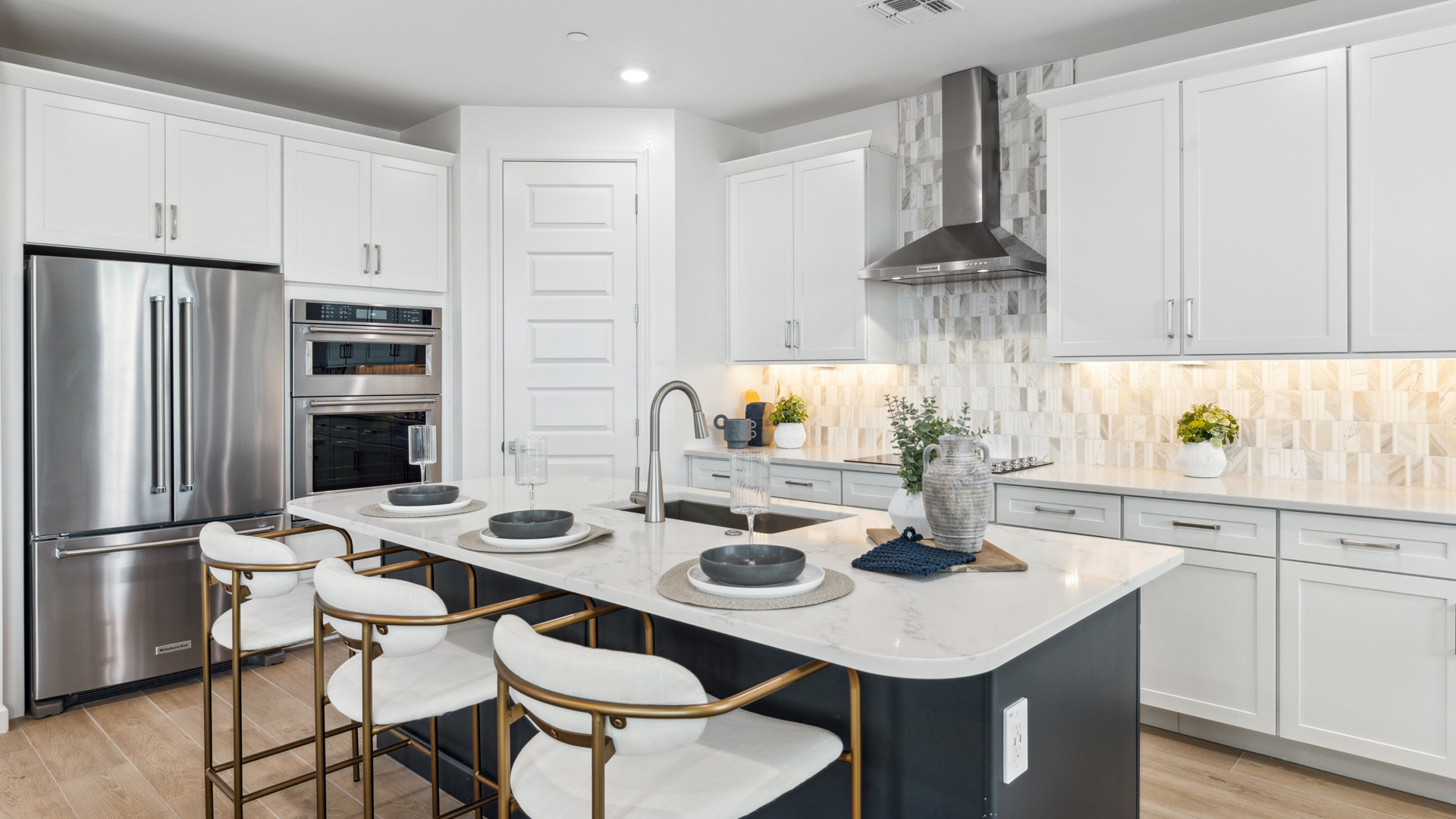 Bright and spacious kitchen with quartz countertops, stainless steel appliances, and an island with bar seating.