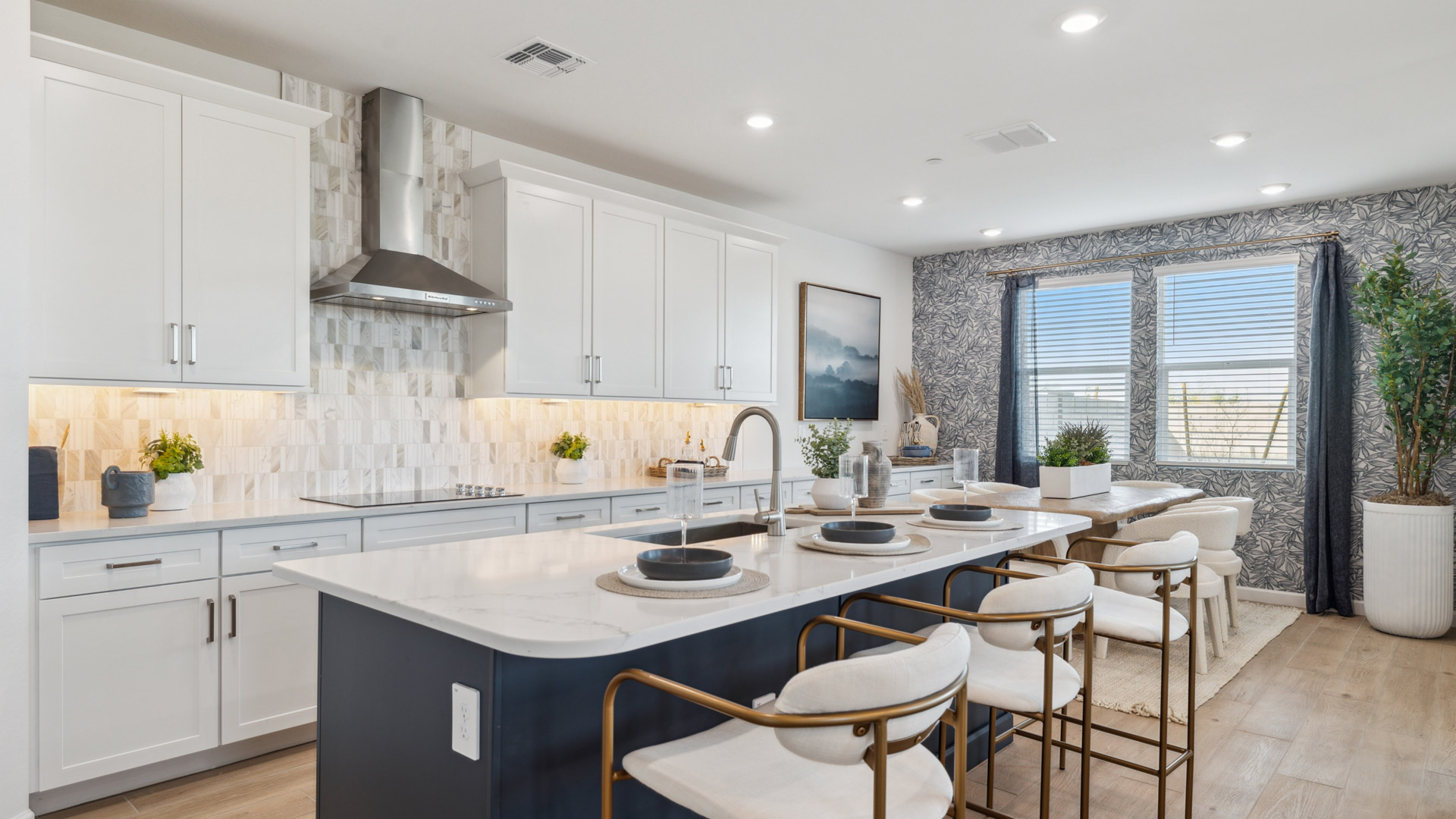 Bright and spacious kitchen with quartz countertops, stainless steel appliances, and an island with bar seating.