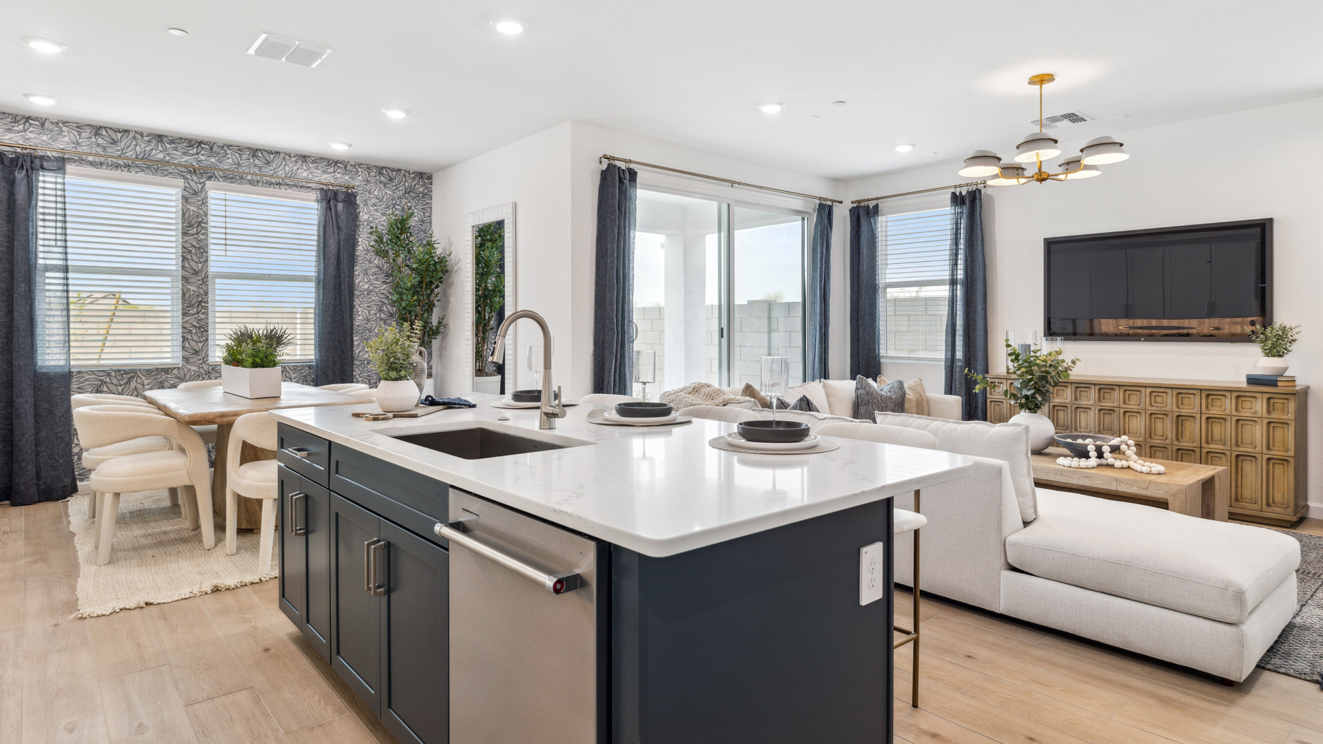 Bright and spacious kitchen with quartz countertops, stainless steel appliances, and an island with bar seating.