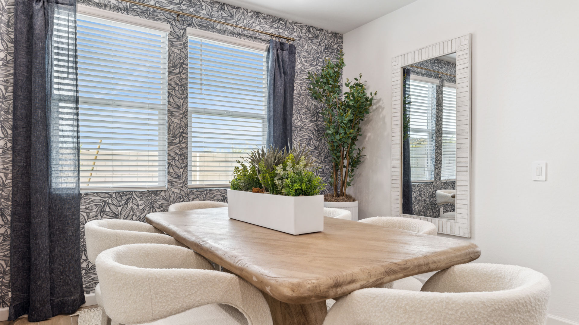 Formal dining room with large windows, vinyl wood floors, and view of the backyard.