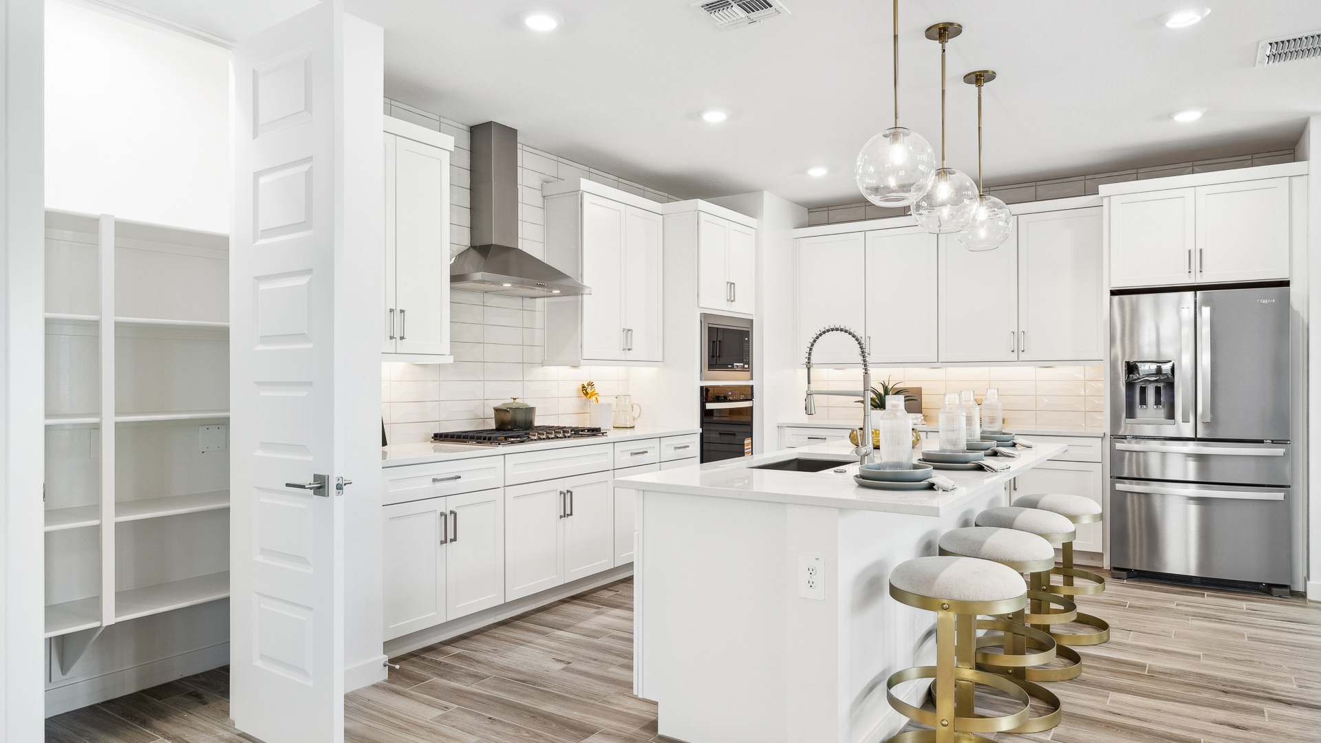 Bright and spacious kitchen with quartz countertops, stainless steel appliances, and an island with bar seating.