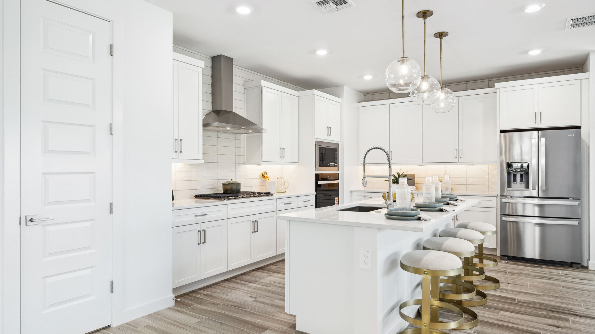 Bright and spacious kitchen with quartz countertops, stainless steel appliances, and an island with bar seating.