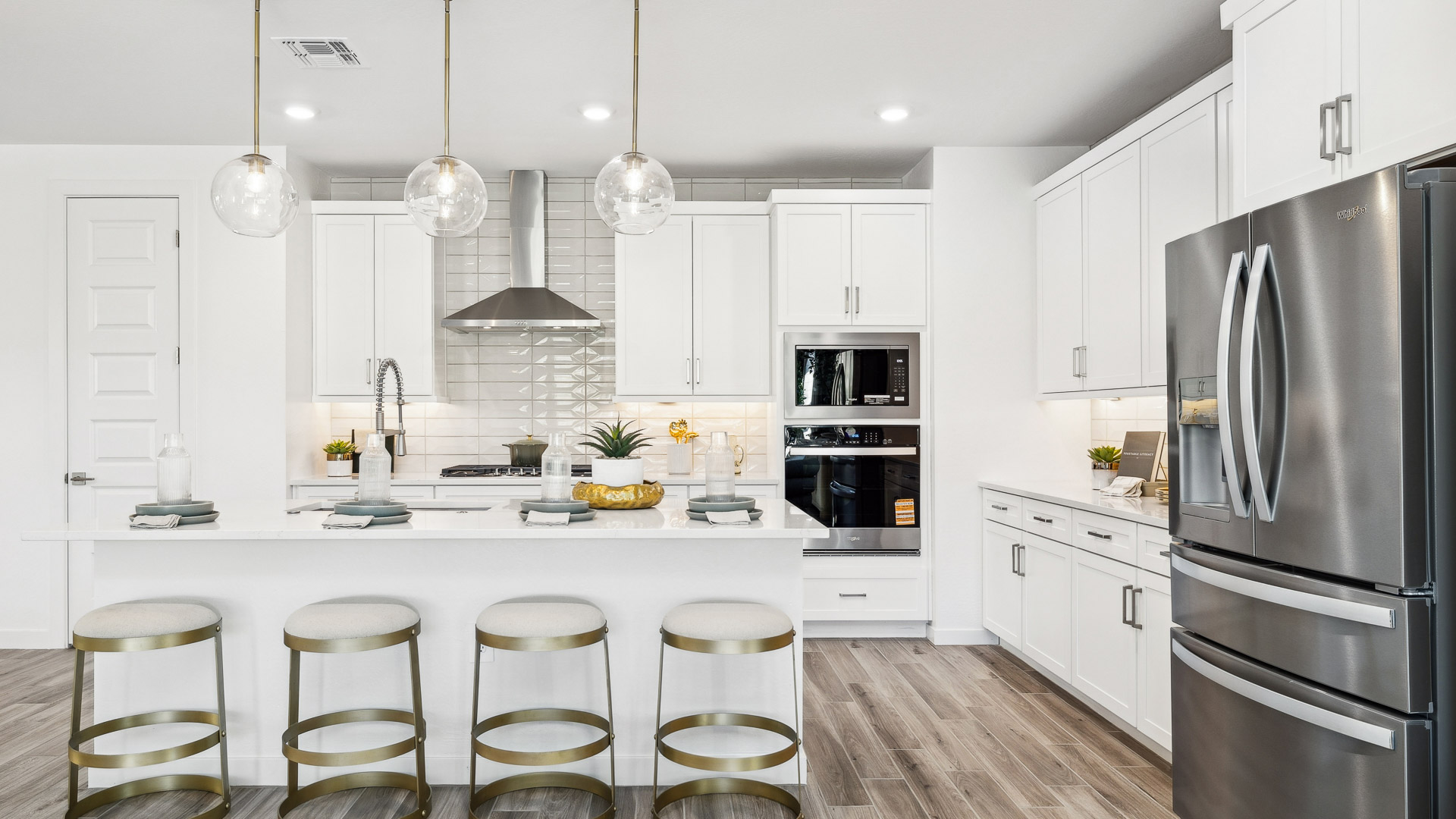 Bright and spacious kitchen with quartz countertops, stainless steel appliances, and an island with bar seating.