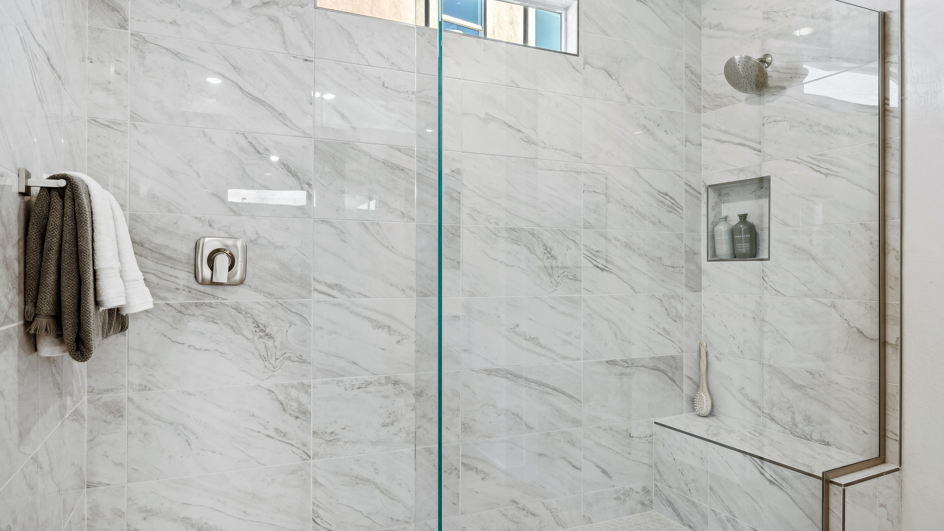 Modern primary bathroom with double vanities, quartz countertops with a walk-in shower and a walk-in closet.
