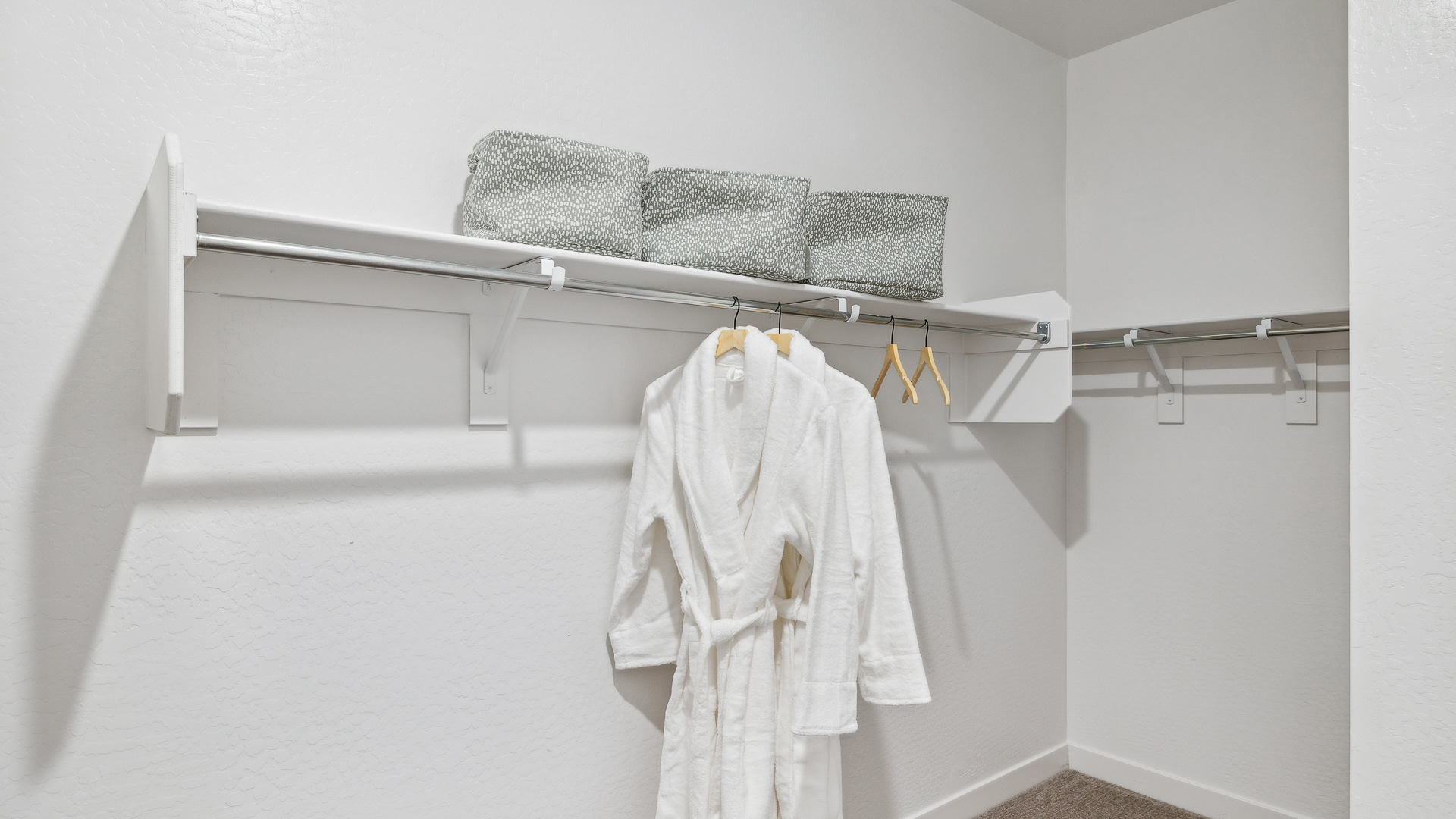 Modern primary bathroom with double vanities, quartz countertops with a walk-in shower and a walk-in closet.
