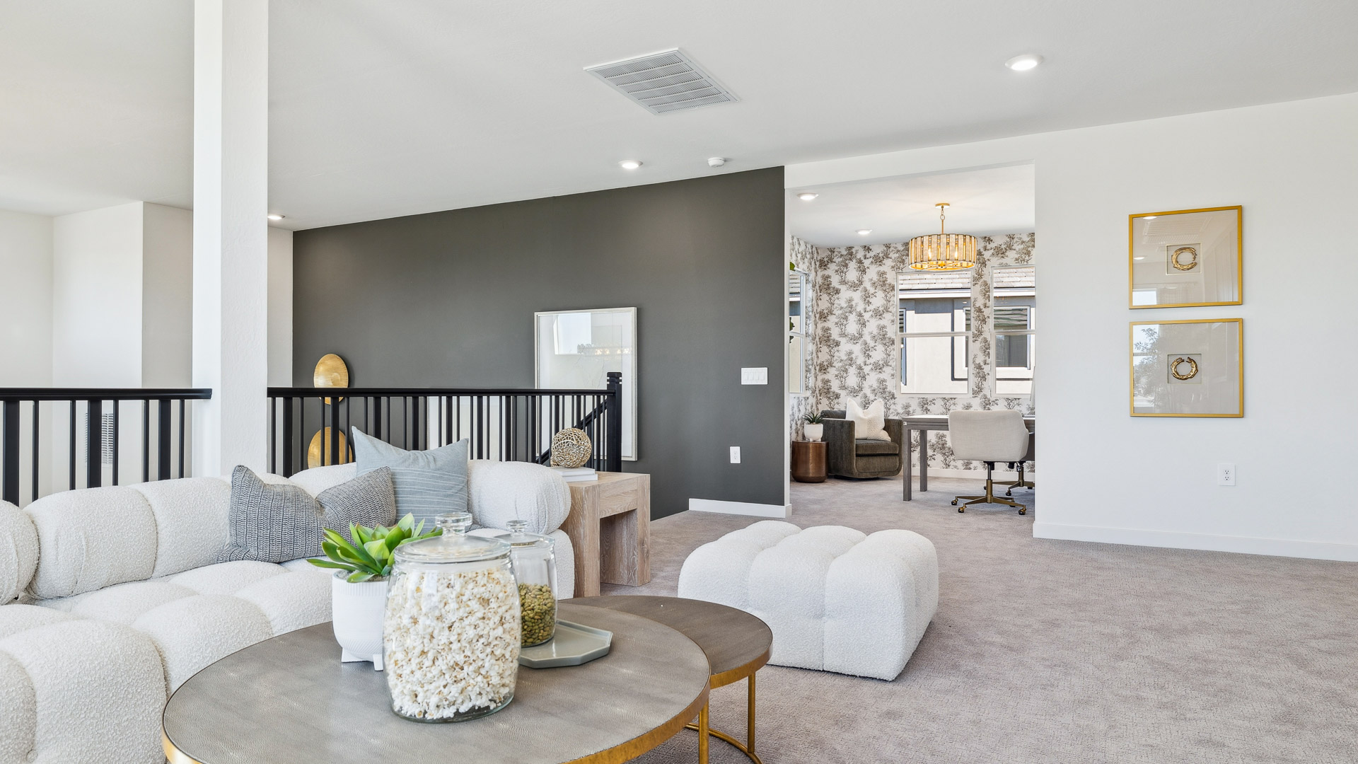 A cozy living room upstairs featuring a comfortable couch, a stylish coffee table, and an elegant painting on the wall.