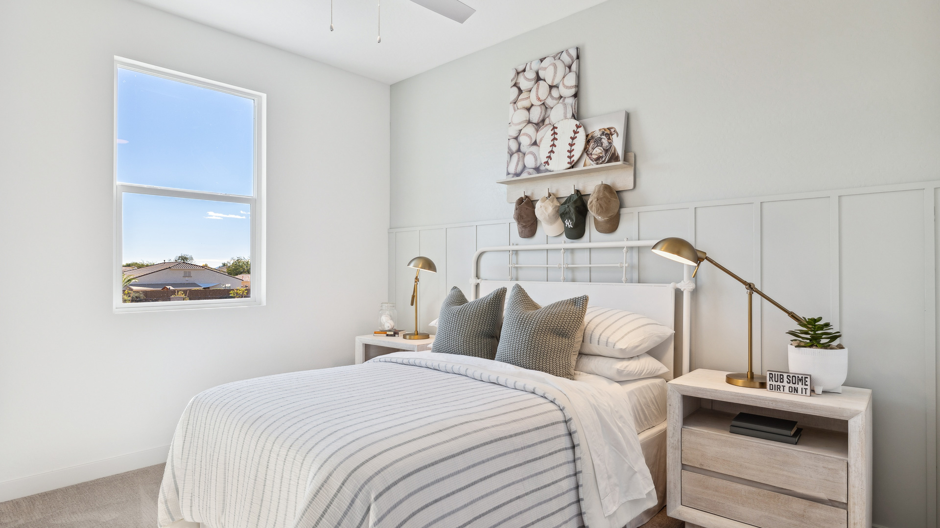 A vibrant kids' bedroom showcasing a neatly made bed, a stylish dresser, and a playful painting that adds charm.