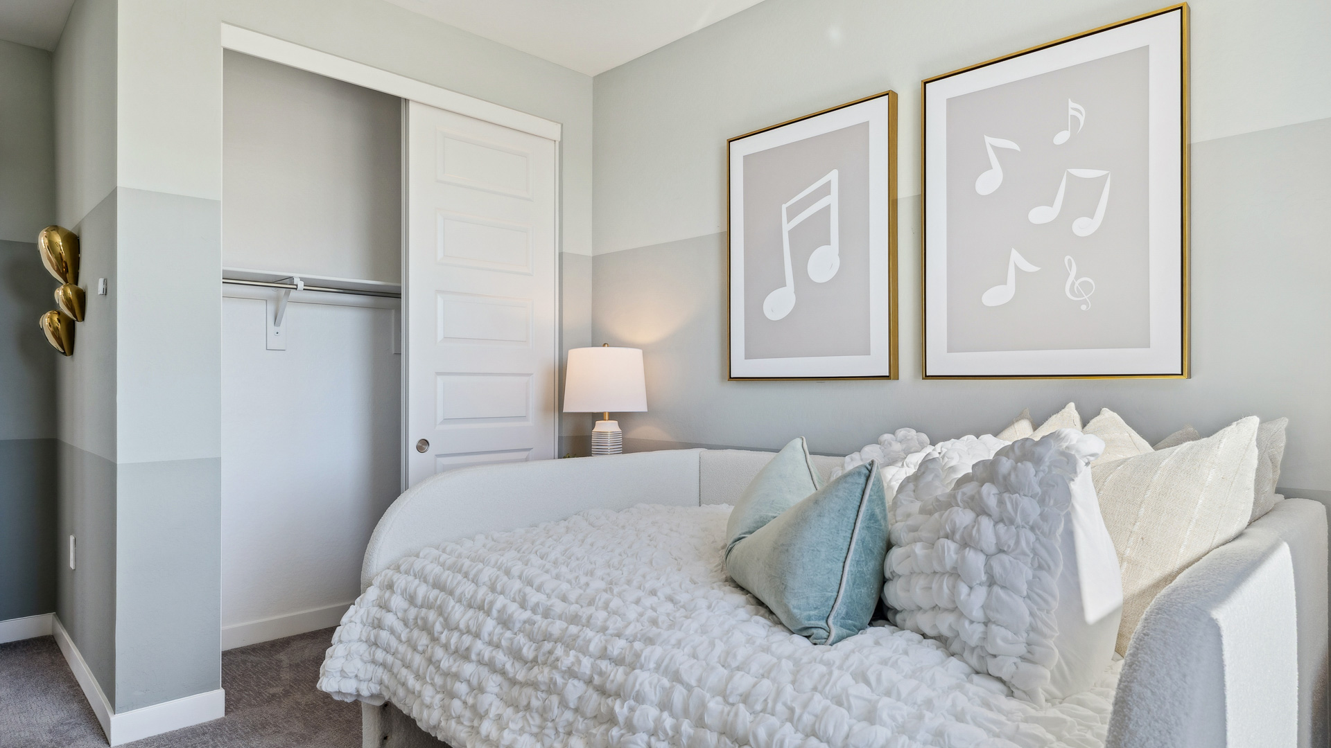 A vibrant kids' bedroom showcasing a neatly made bed, a stylish dresser, and a playful painting that adds charm.