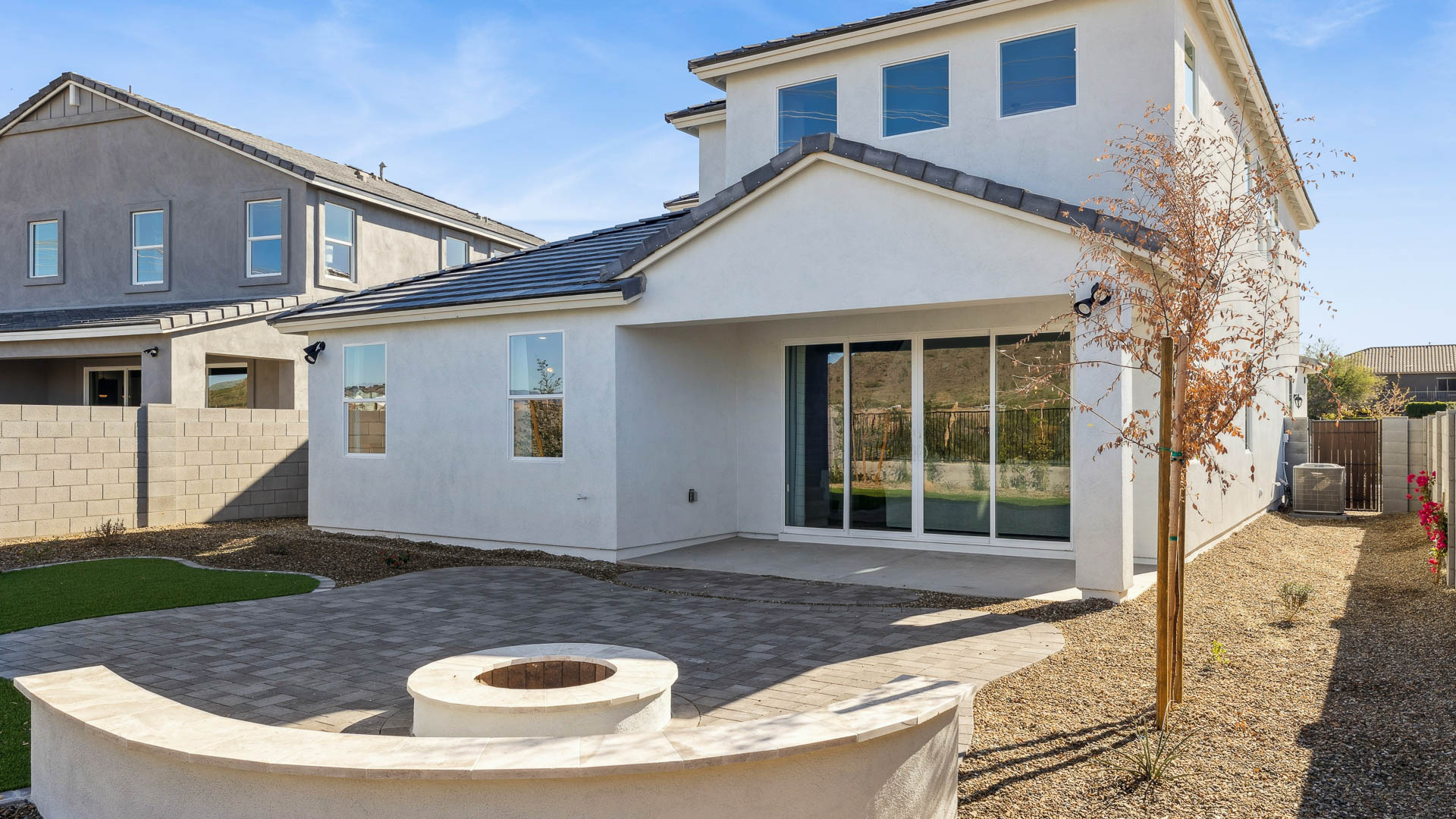 Outdoor covered patio with seating area overlooking a well-maintained lawn, perfect for relaxation.