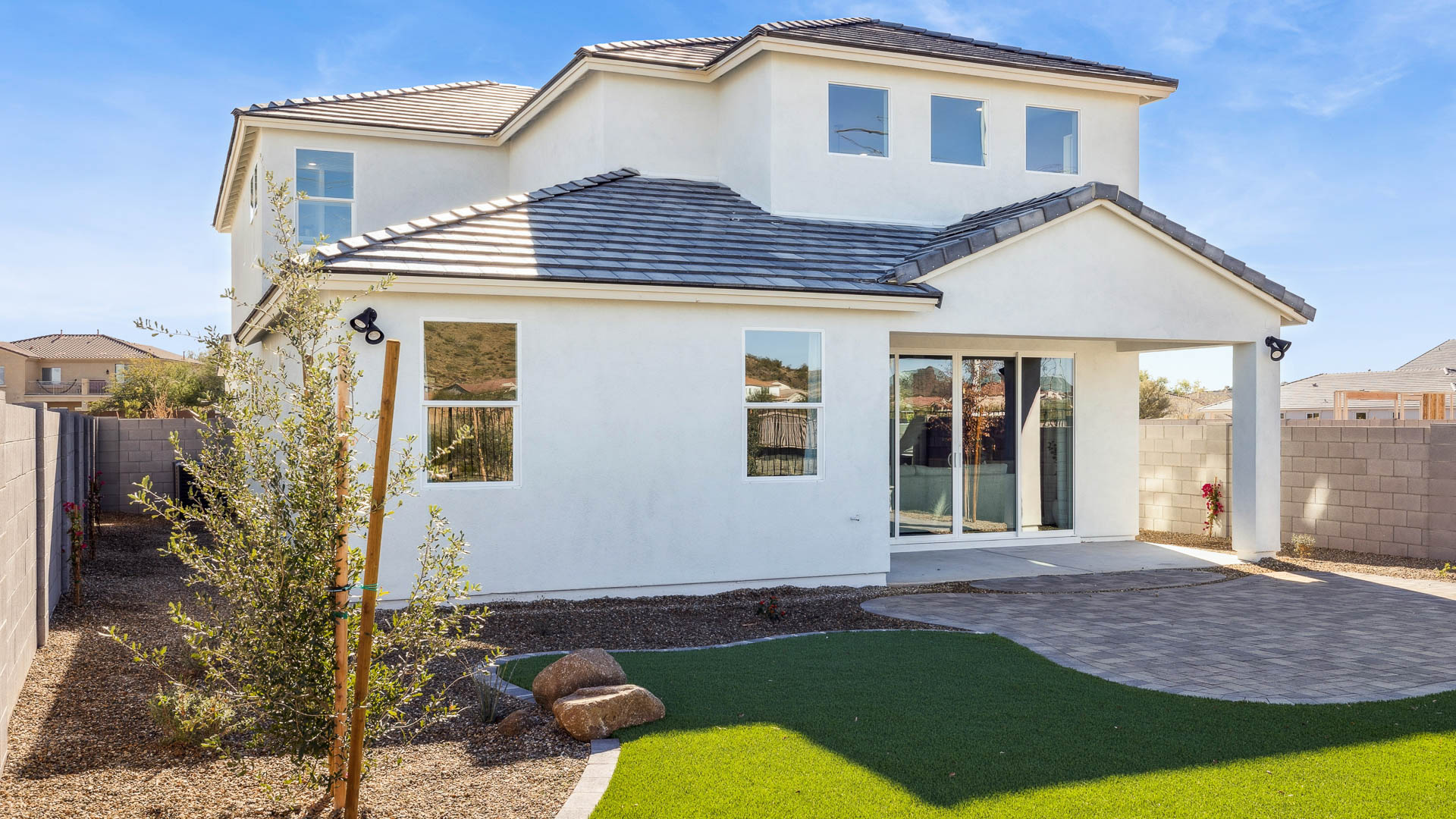 Outdoor covered patio with seating area overlooking a well-maintained lawn, perfect for relaxation.