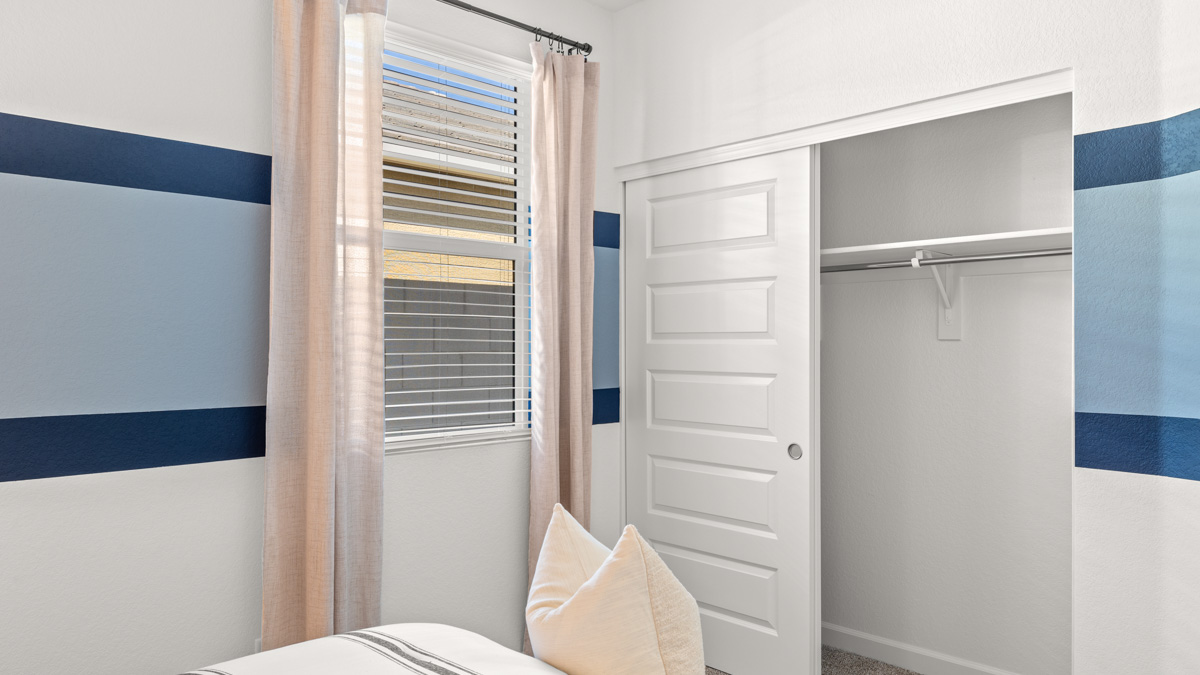 A vibrant kids' bedroom showcasing a neatly made bed, a stylish dresser, and a playful painting that adds charm.