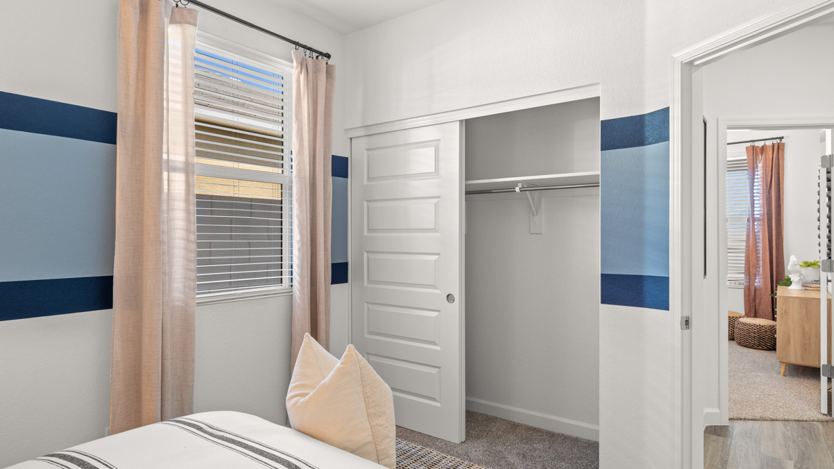 A vibrant kids' bedroom showcasing a neatly made bed, a stylish dresser, and a playful painting that adds charm.