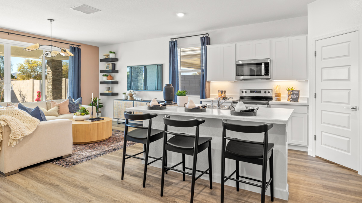 Bright and spacious kitchen with quartz countertops, stainless steel appliances, and an island with bar seating.