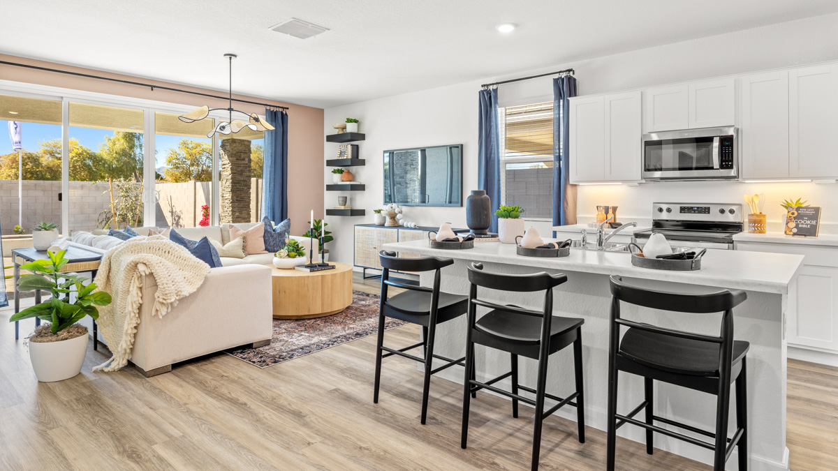Bright and spacious kitchen with quartz countertops, stainless steel appliances, and an island with bar seating.