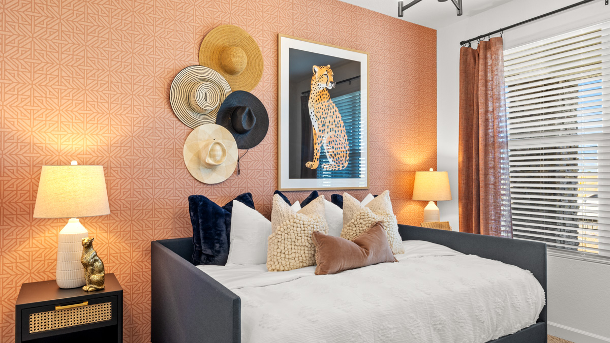 A vibrant kids' bedroom showcasing a neatly made bed, a stylish dresser, and a playful painting that adds charm.