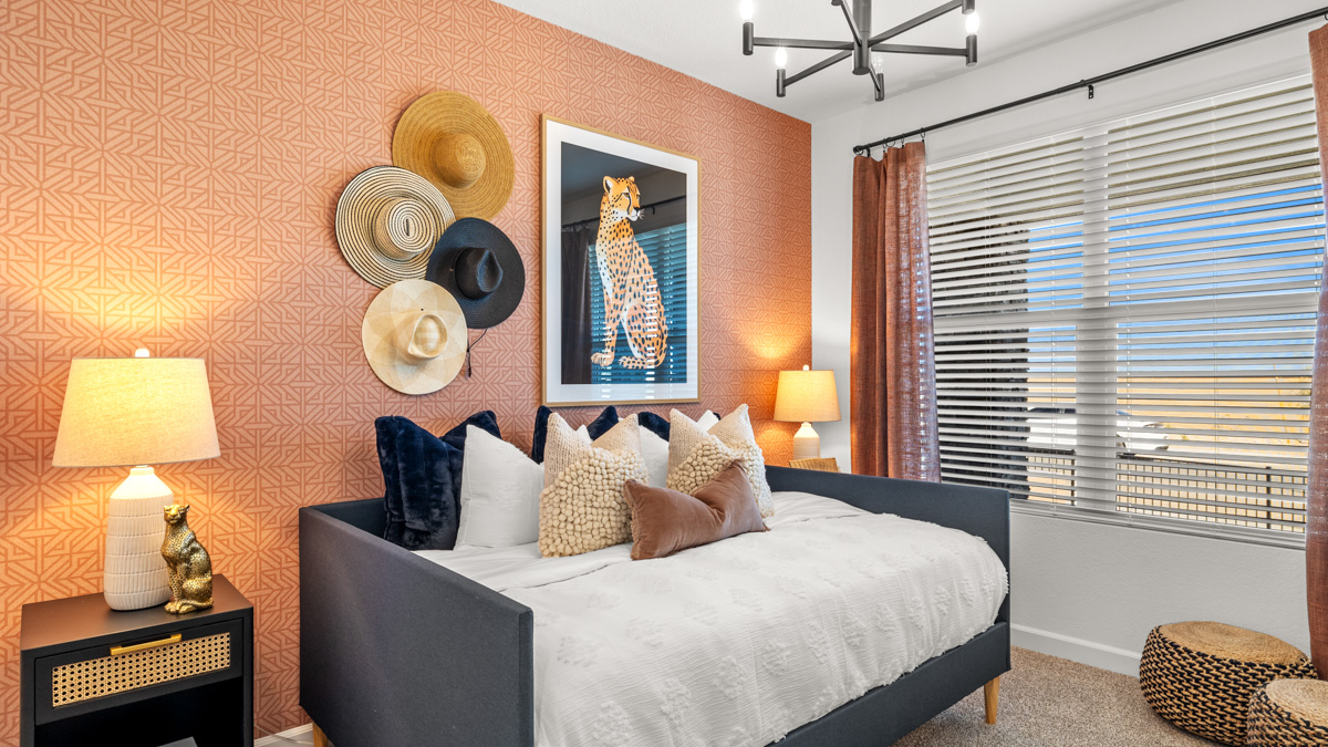A vibrant kids' bedroom showcasing a neatly made bed, a stylish dresser, and a playful painting that adds charm.