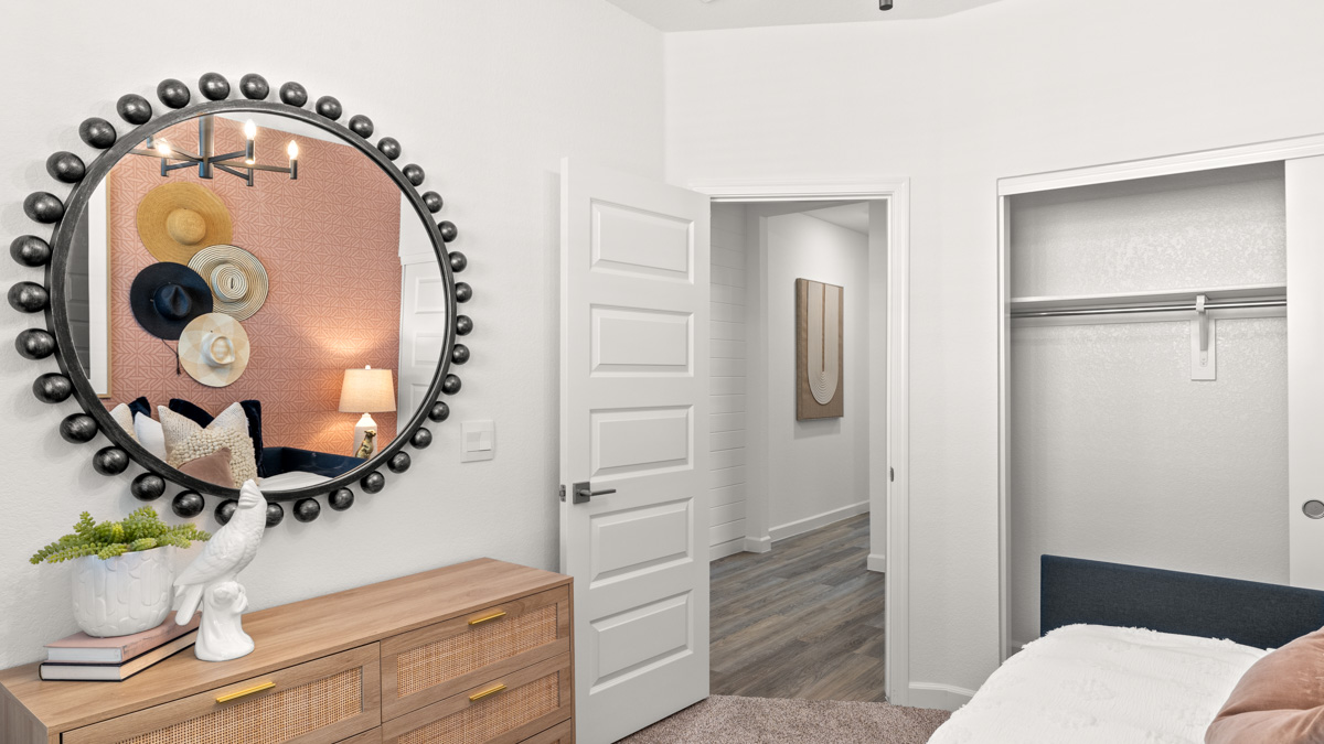 A vibrant kids' bedroom showcasing a neatly made bed, a stylish dresser, and a playful painting that adds charm.