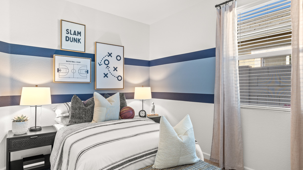 A vibrant kids' bedroom showcasing a neatly made bed, a stylish dresser, and a playful painting that adds charm.