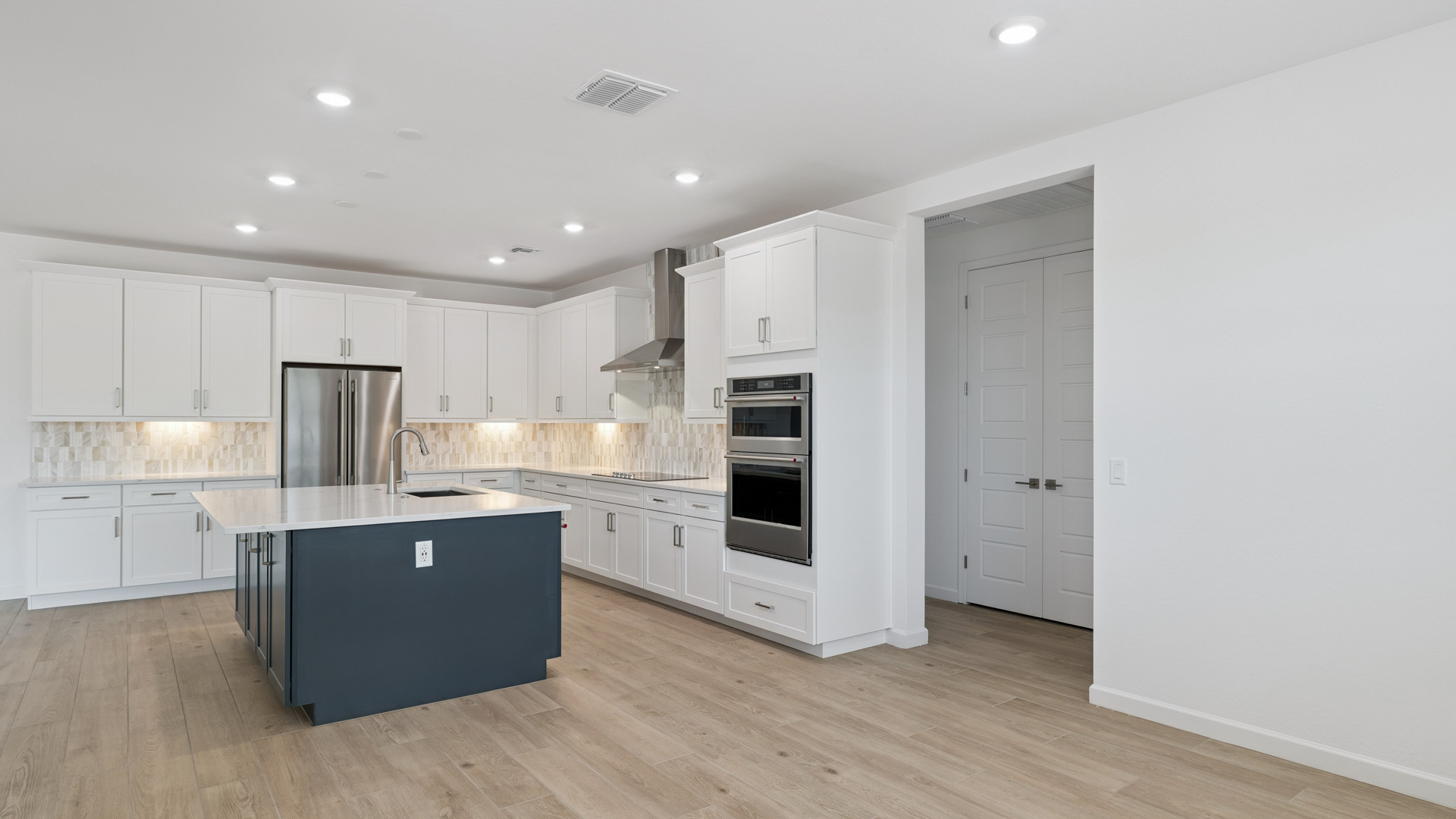 Bright and spacious kitchen with quartz countertops, stainless steel appliances, and an island with bar seating.