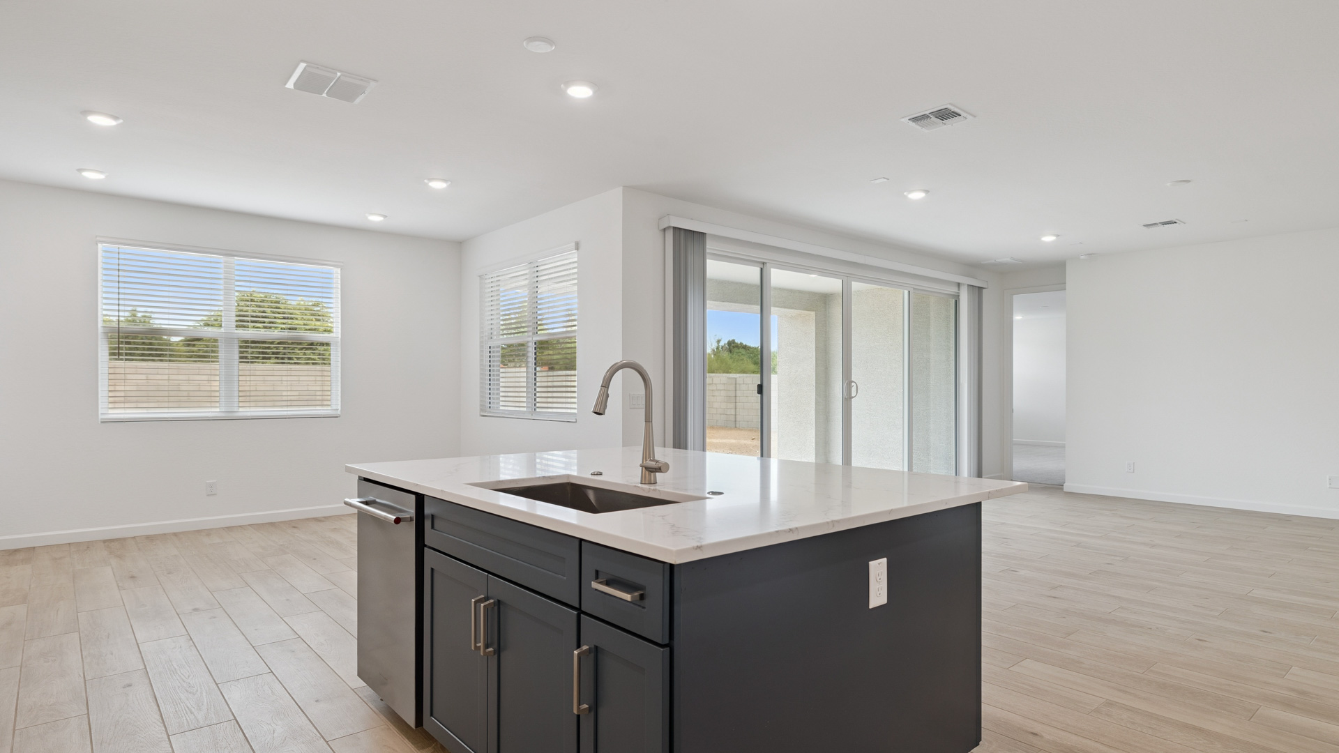 Bright and spacious kitchen with quartz countertops, stainless steel appliances, and an island with bar seating.