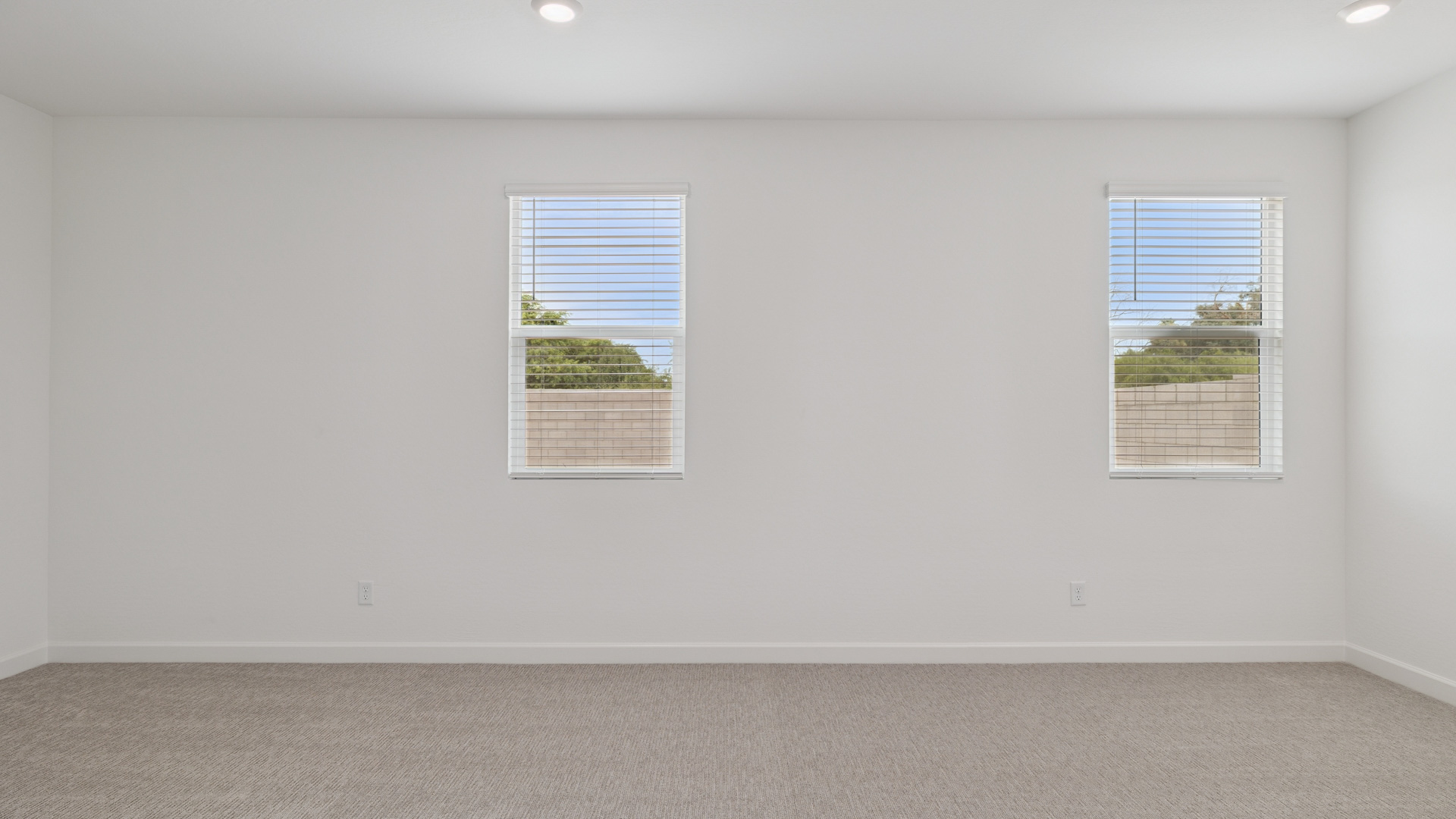 A spacious primary bedroom emphasizing open space and natural lighting.