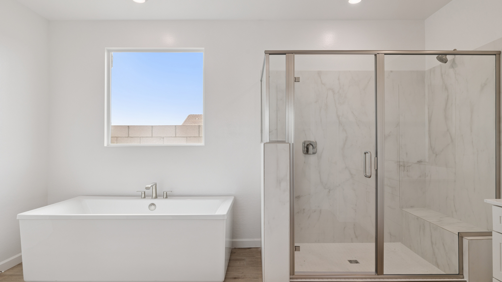 Modern primary bathroom with double vanities, quartz countertops with a walk-in shower and a walk-in closet.