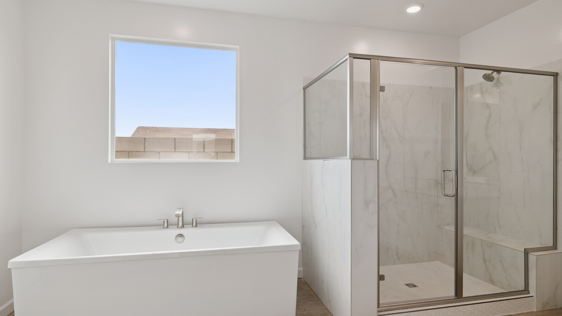 Modern primary bathroom with double vanities, quartz countertops with a walk-in shower and a walk-in closet.