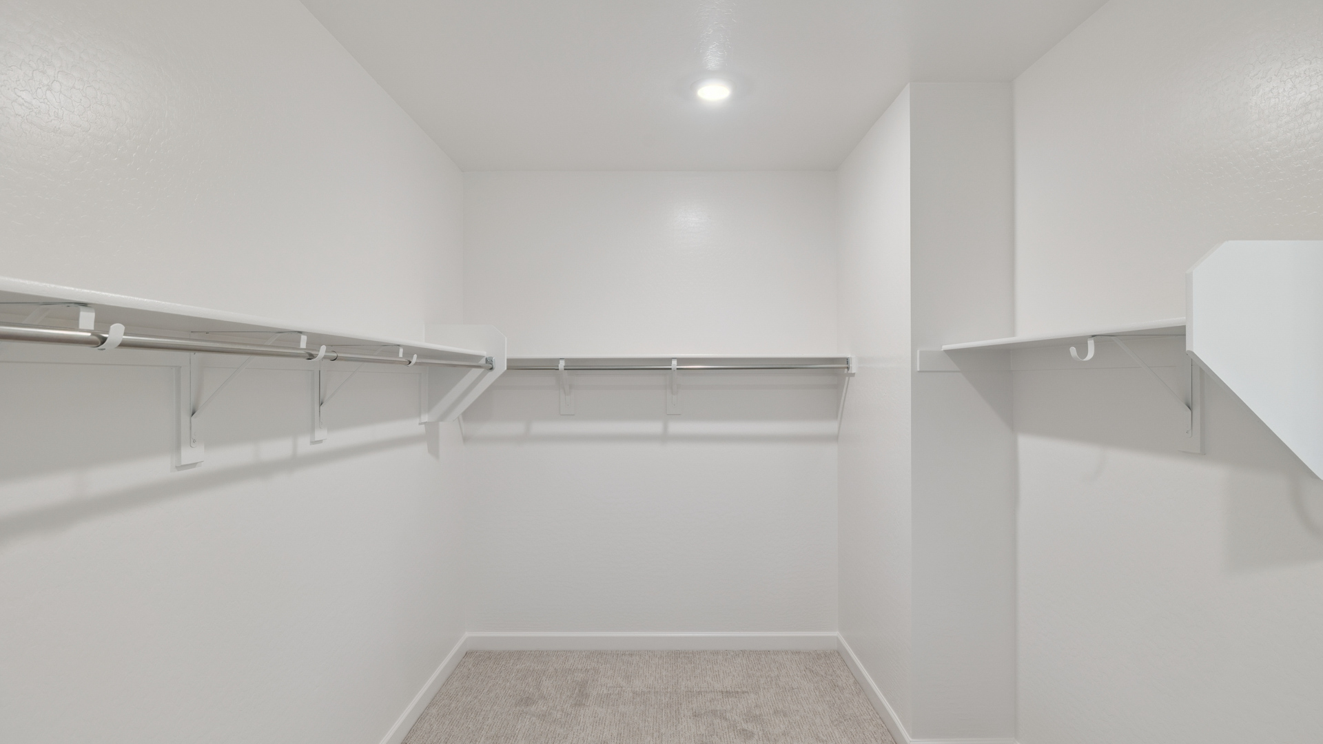 Modern primary bathroom with double vanities, quartz countertops with a walk-in shower and a walk-in closet.