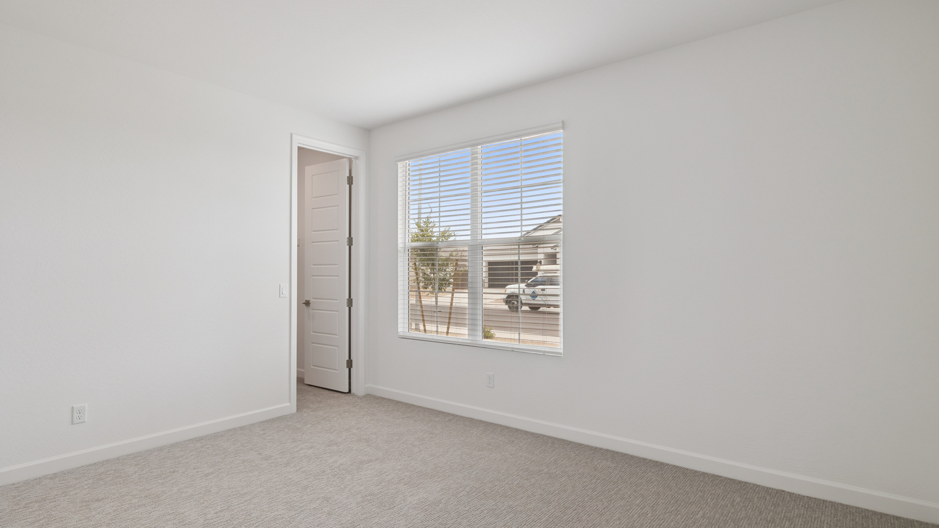 Comfortable guest bedroom featuring neutral-toned walls and a large closet.