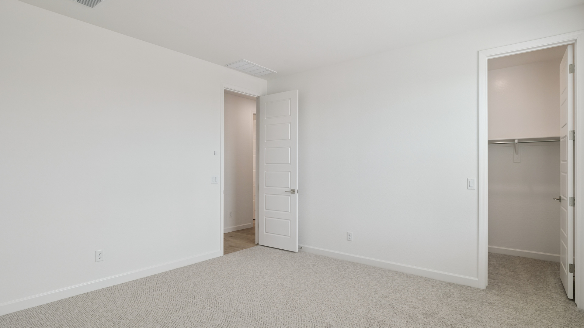 Comfortable guest bedroom featuring neutral-toned walls and a large closet.