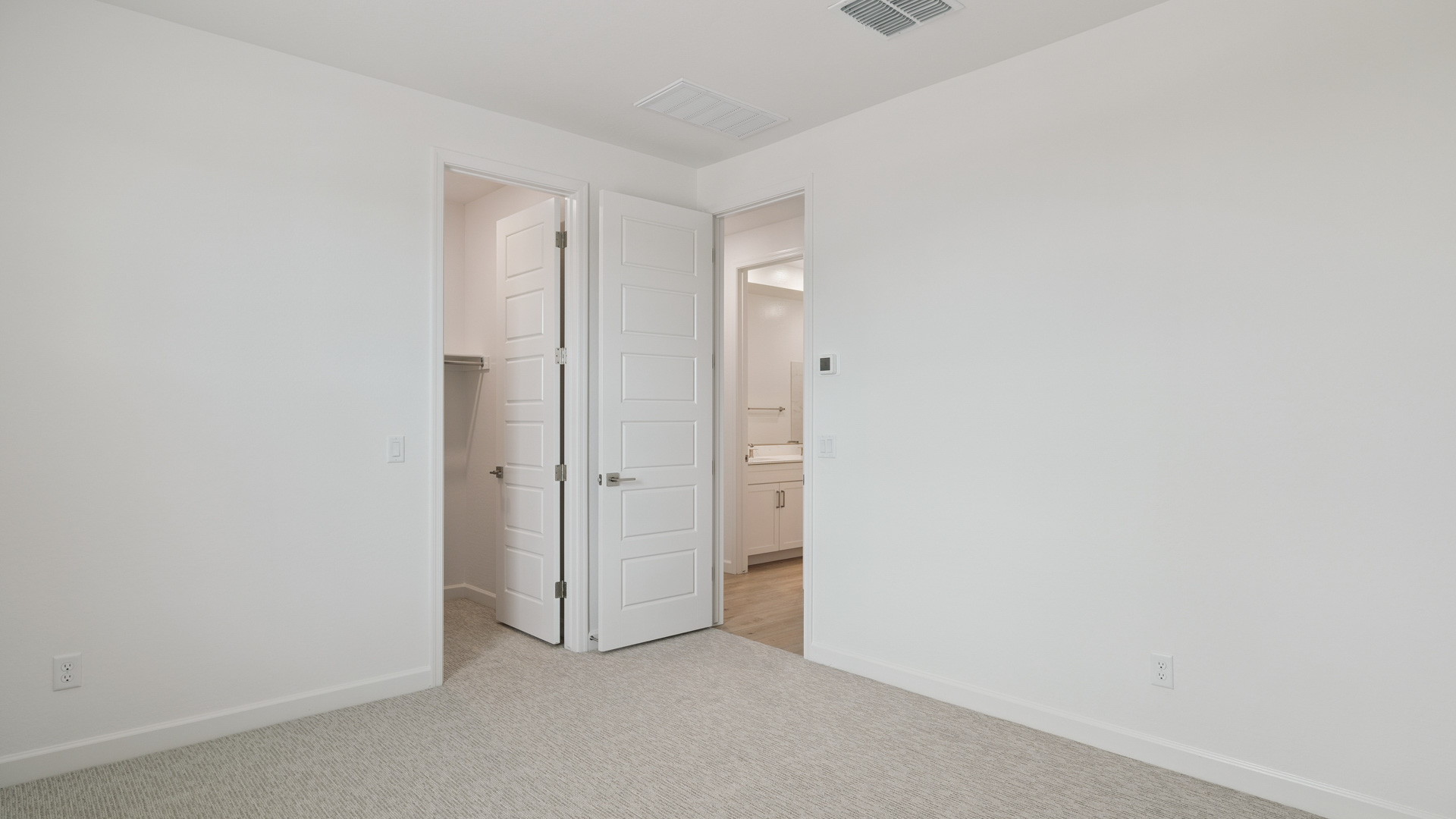 Comfortable guest bedroom featuring neutral-toned walls and a large closet.