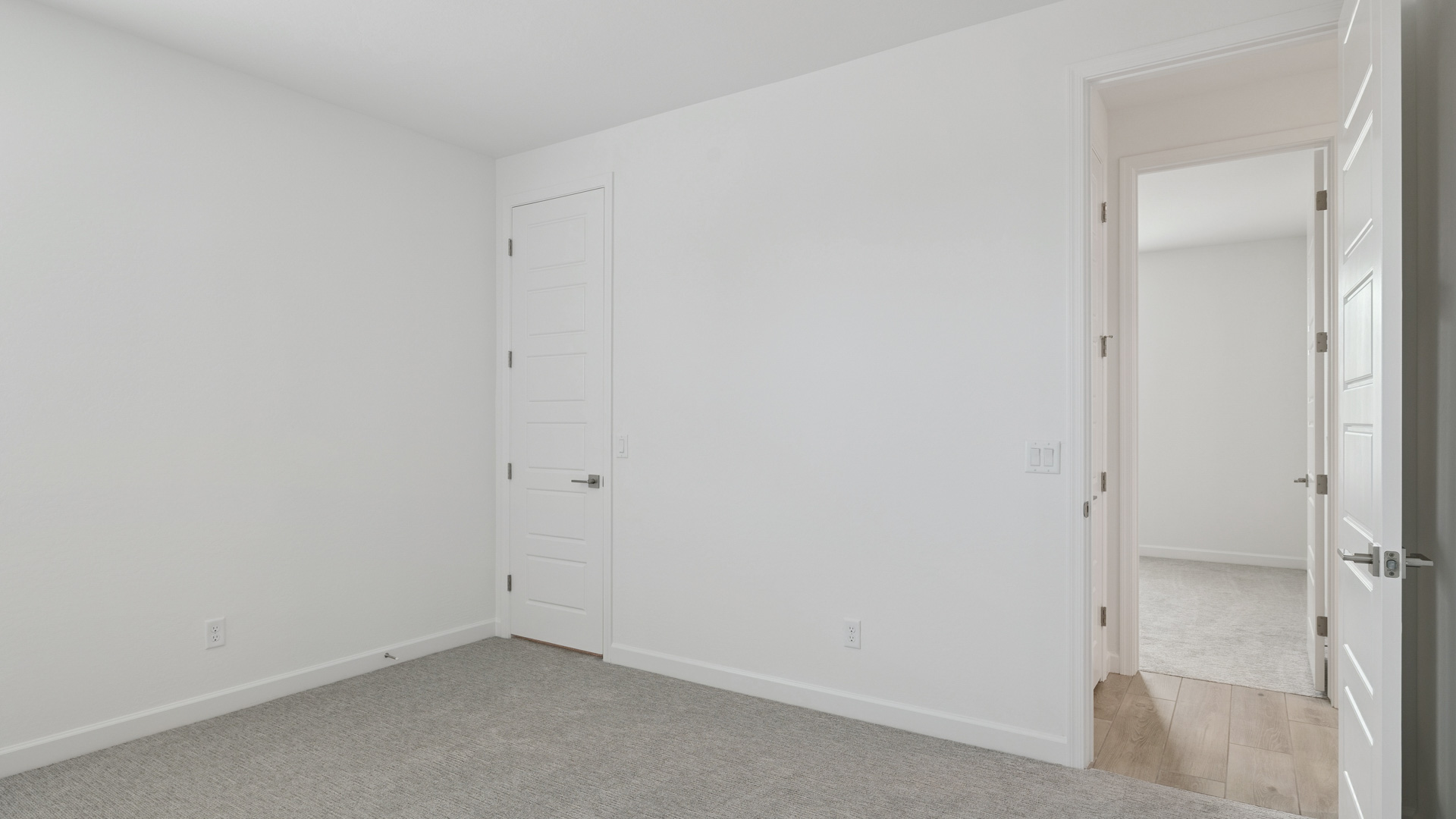 Comfortable guest bedroom featuring neutral-toned walls and a large closet.