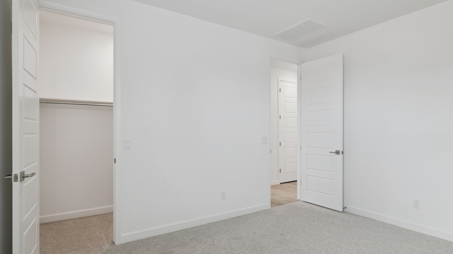Comfortable guest bedroom featuring neutral-toned walls and a large closet.