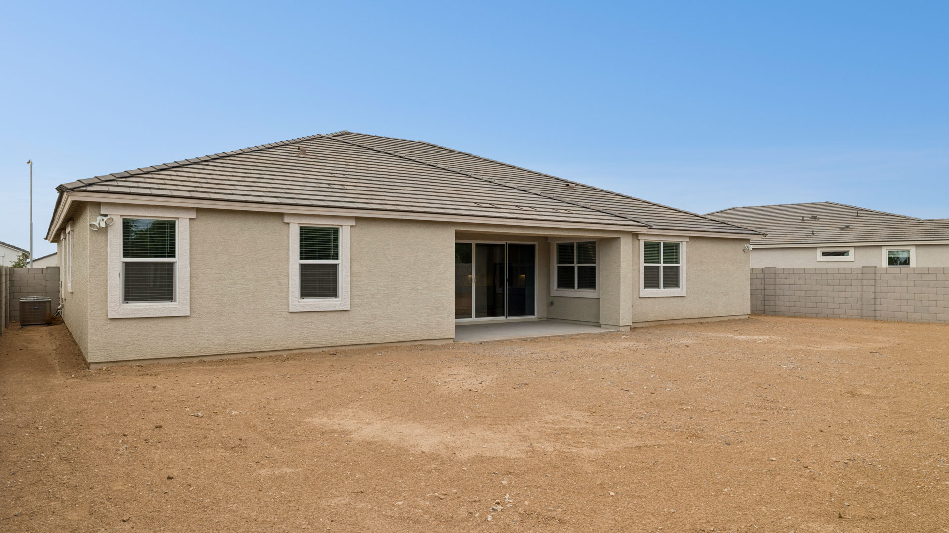 Outdoor covered patio with seating area overlooking a well-maintained lawn, perfect for relaxation.